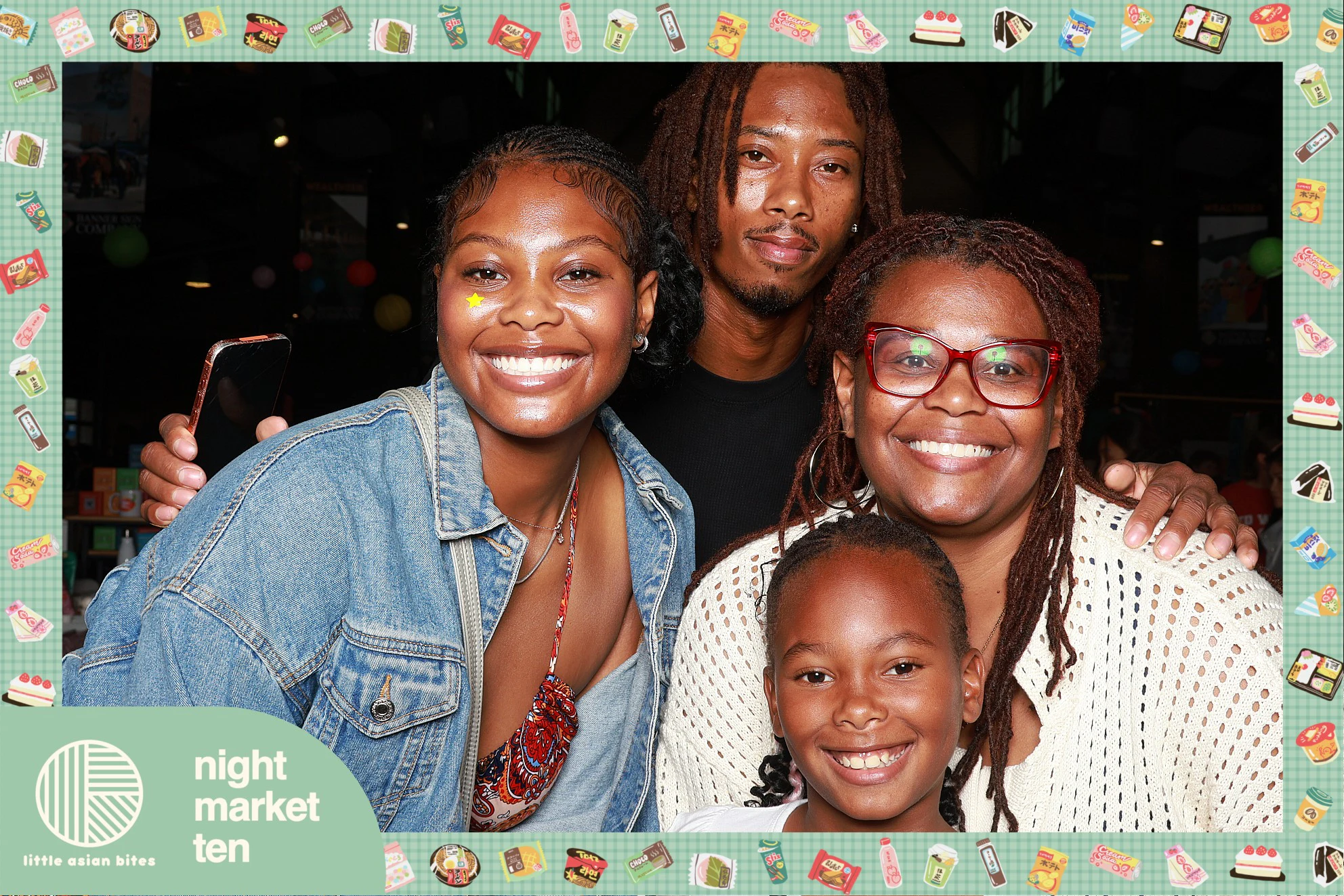Family of four, the youngest grinning up front at Little Asian Bites Night Market