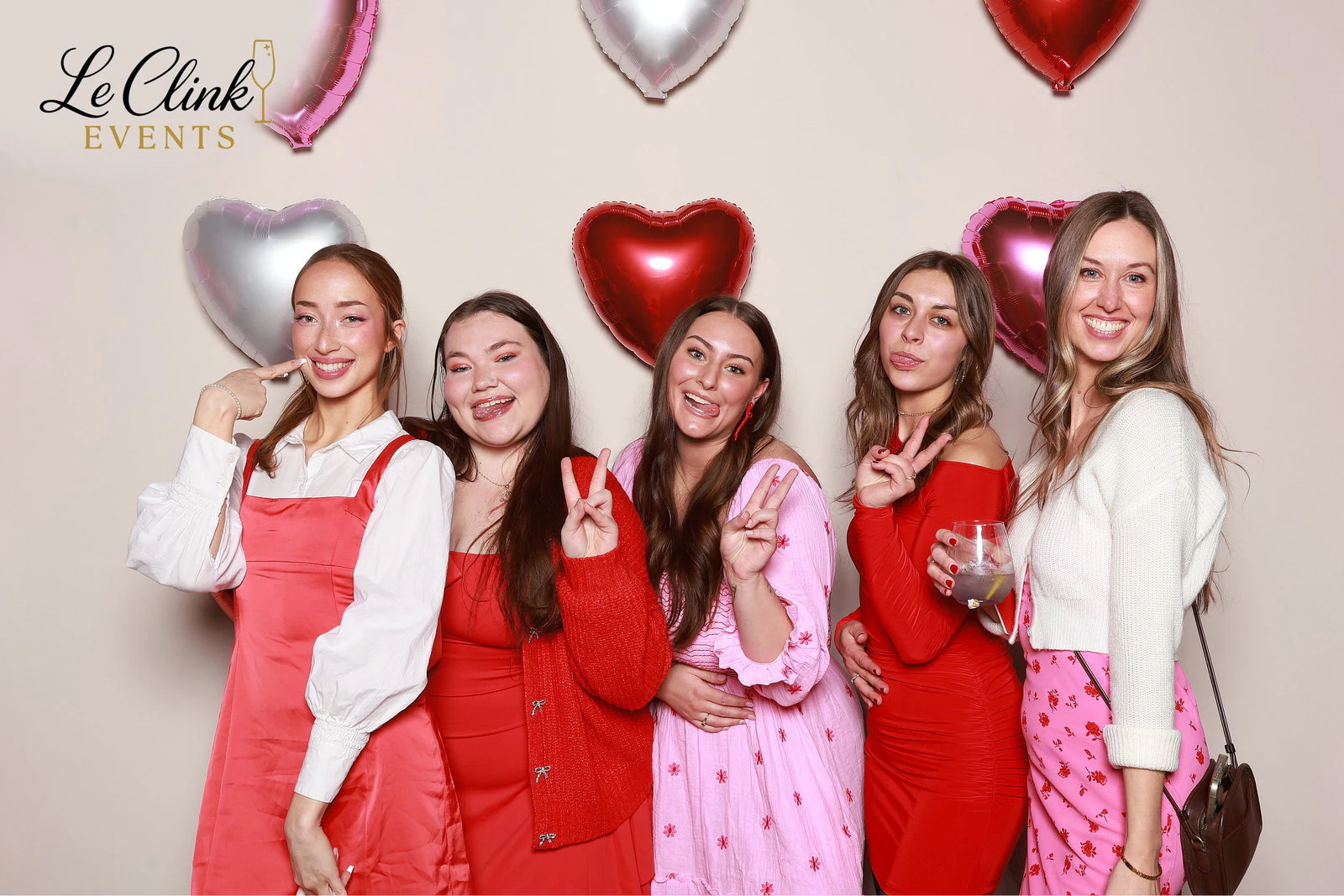 Five women in pink, red and white in front of a wall of red, pink and silver heart balloons at LivCo Galentine’s