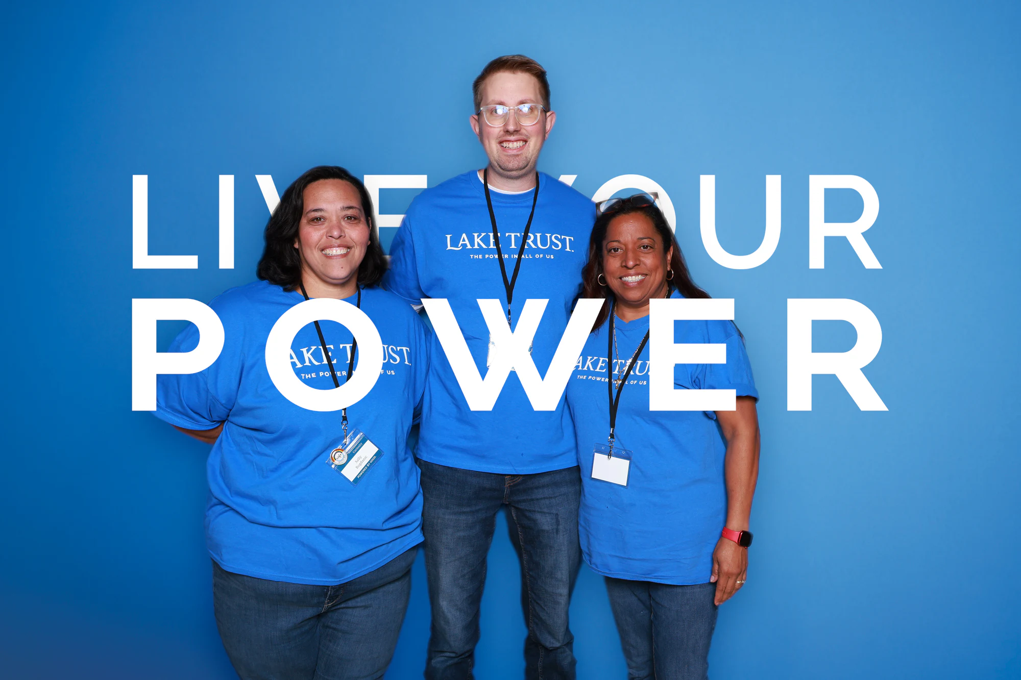 Three guests in Lake Trust shirts standing together at Live Your Power