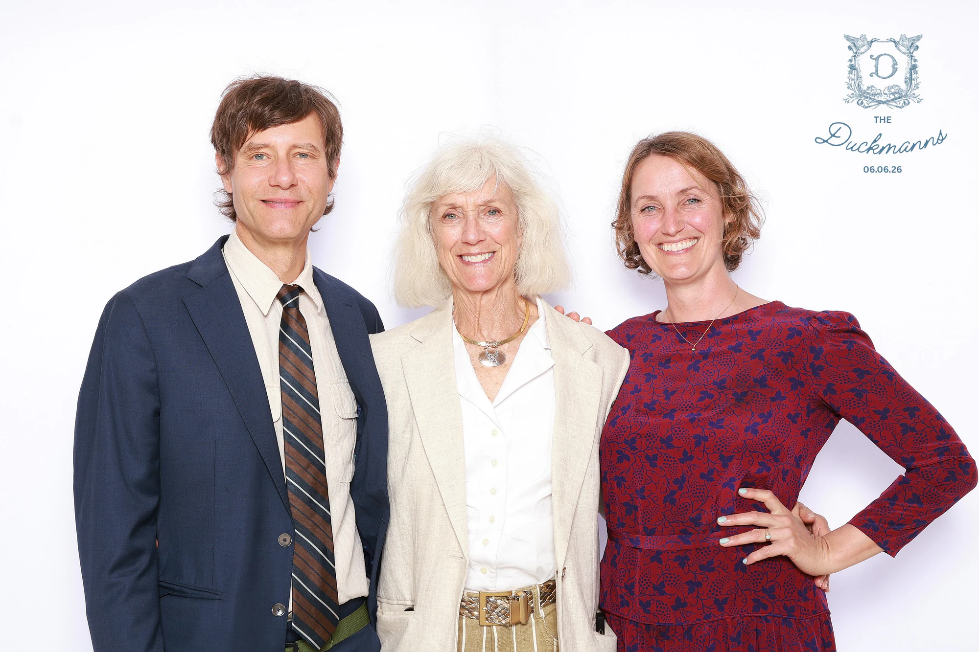 A man in a navy jacket and striped tie with two women, all three smiling at Melissa + Crosley