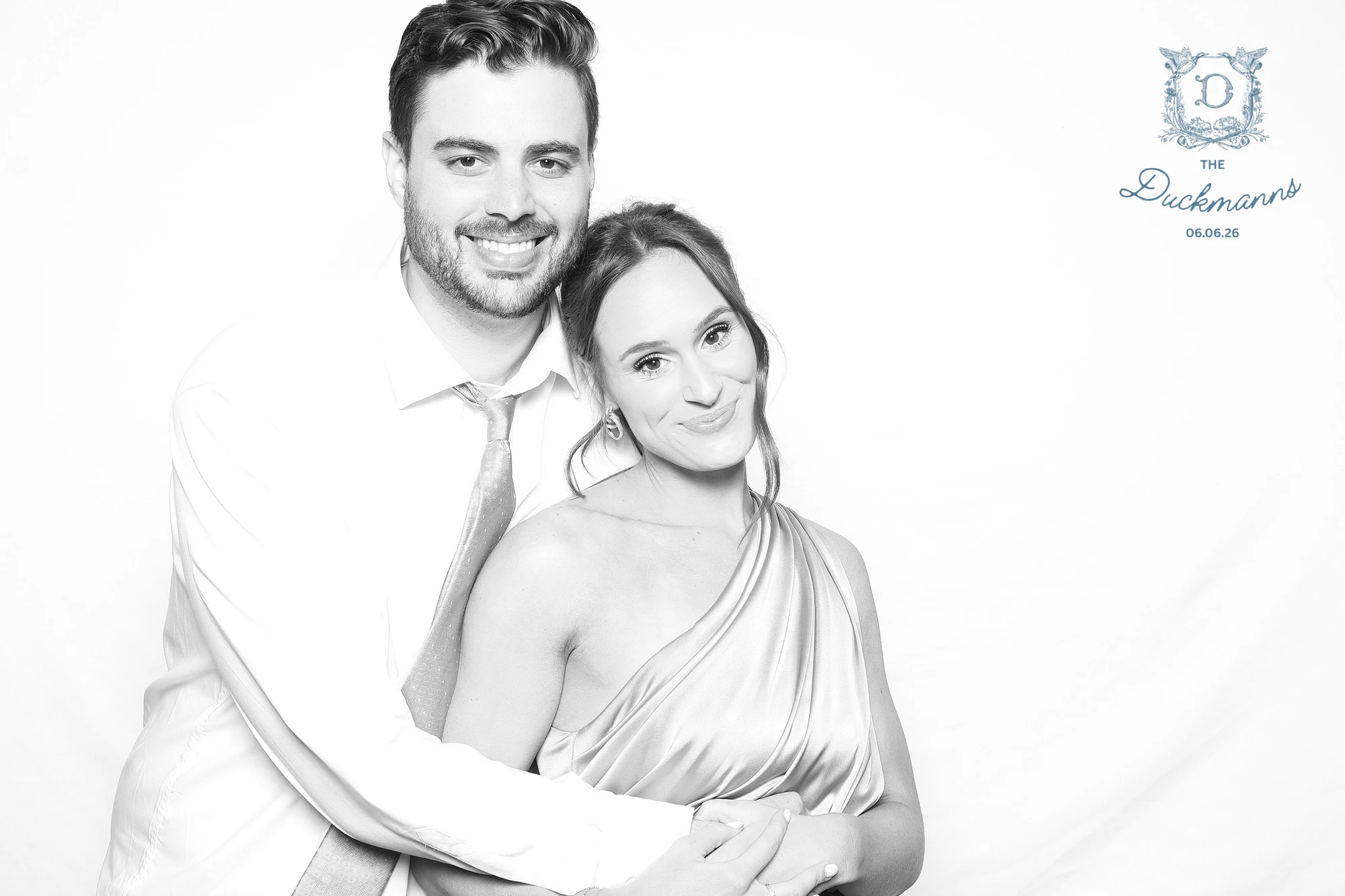 A couple in black and white with his arms around her and their heads together at Melissa + Crosley