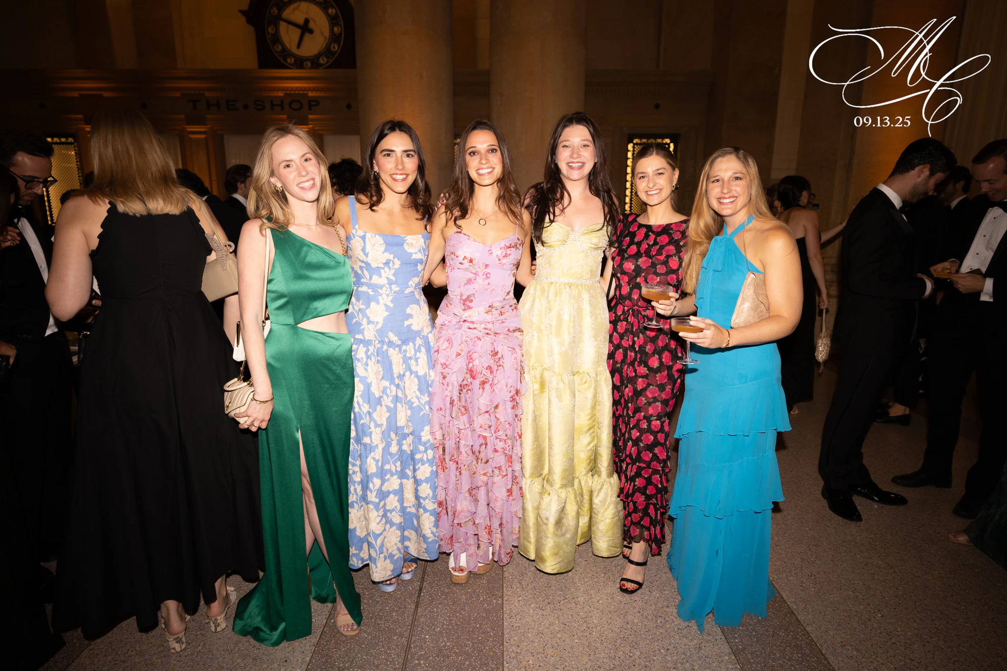 Five women in florals against the stone, the couple’s monogram in the corner, at Madison + Charlie at Michigan Central