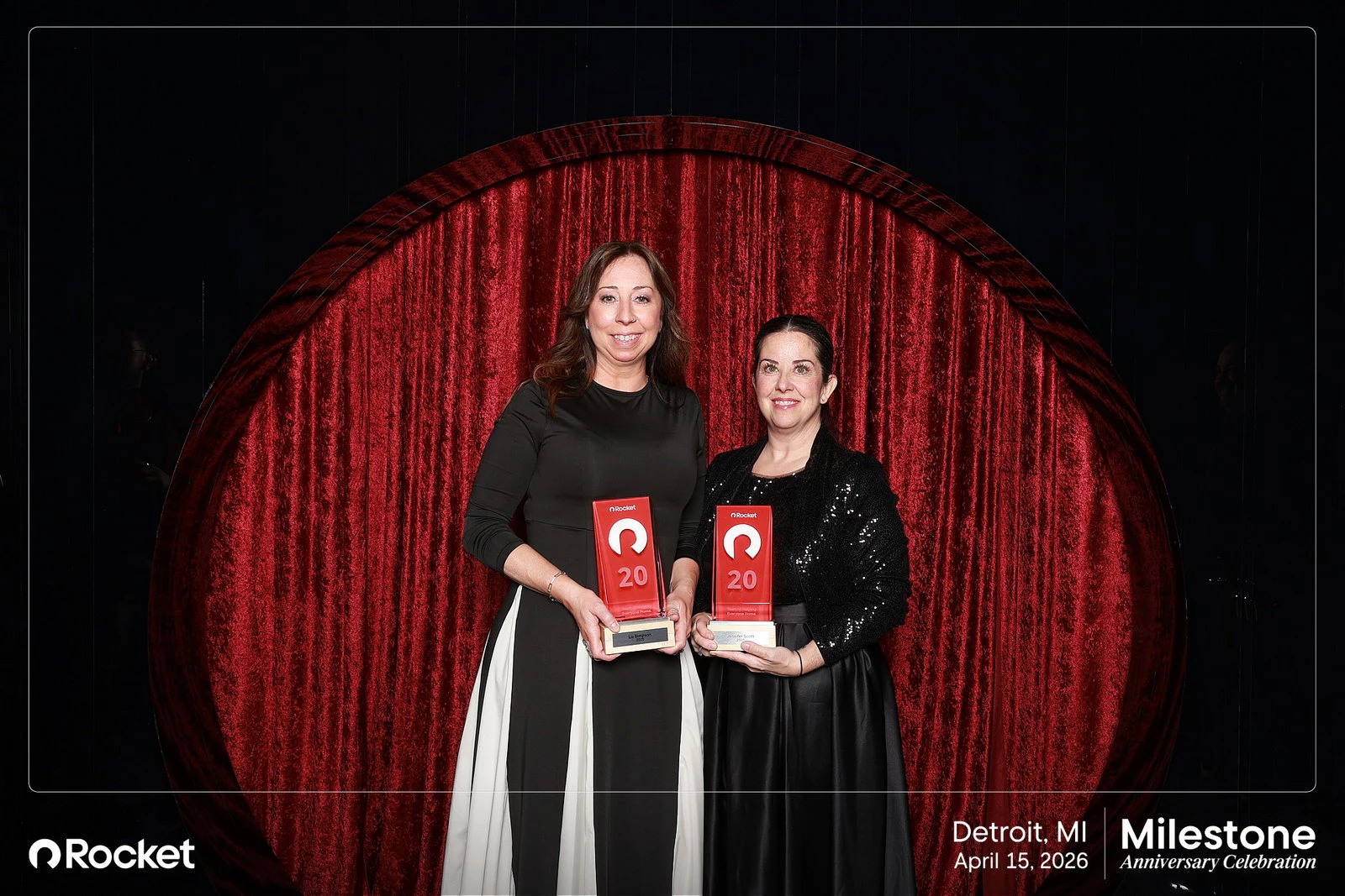 Two women in long black skirts, each holding a red plaque at Milestone Anniversary Celebration
