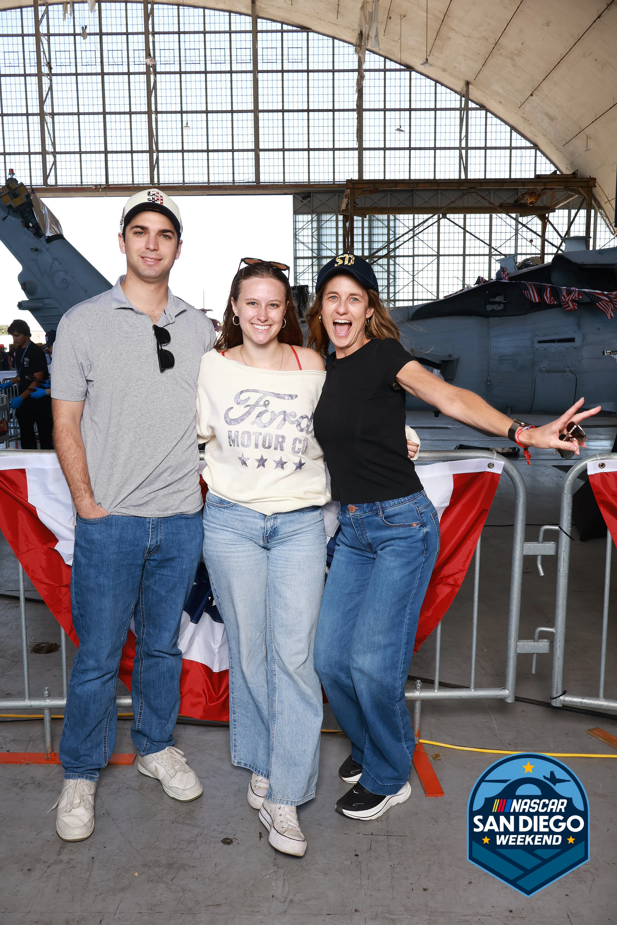 Three friends, the woman on the right mid-laugh at NASCAR San Diego