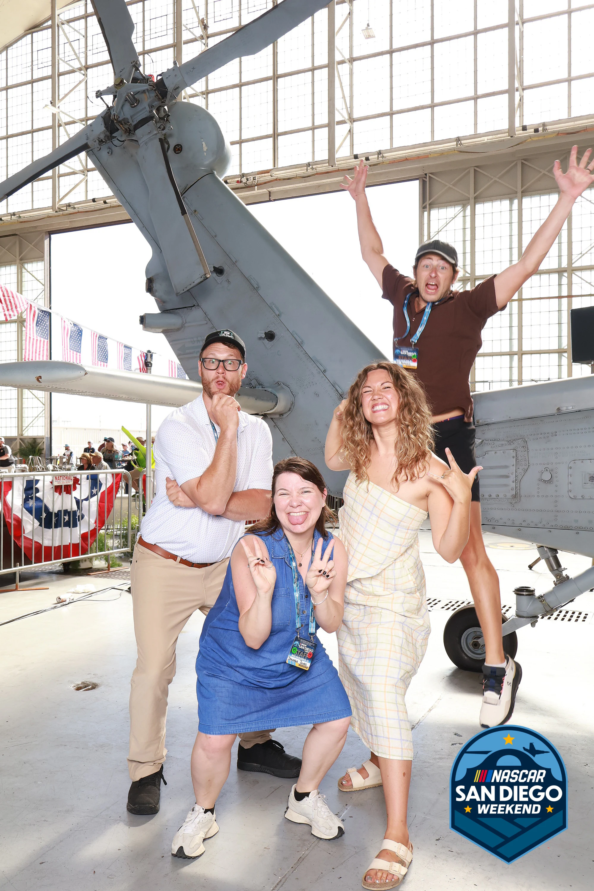 Four with arms up under the helicopter at NASCAR San Diego