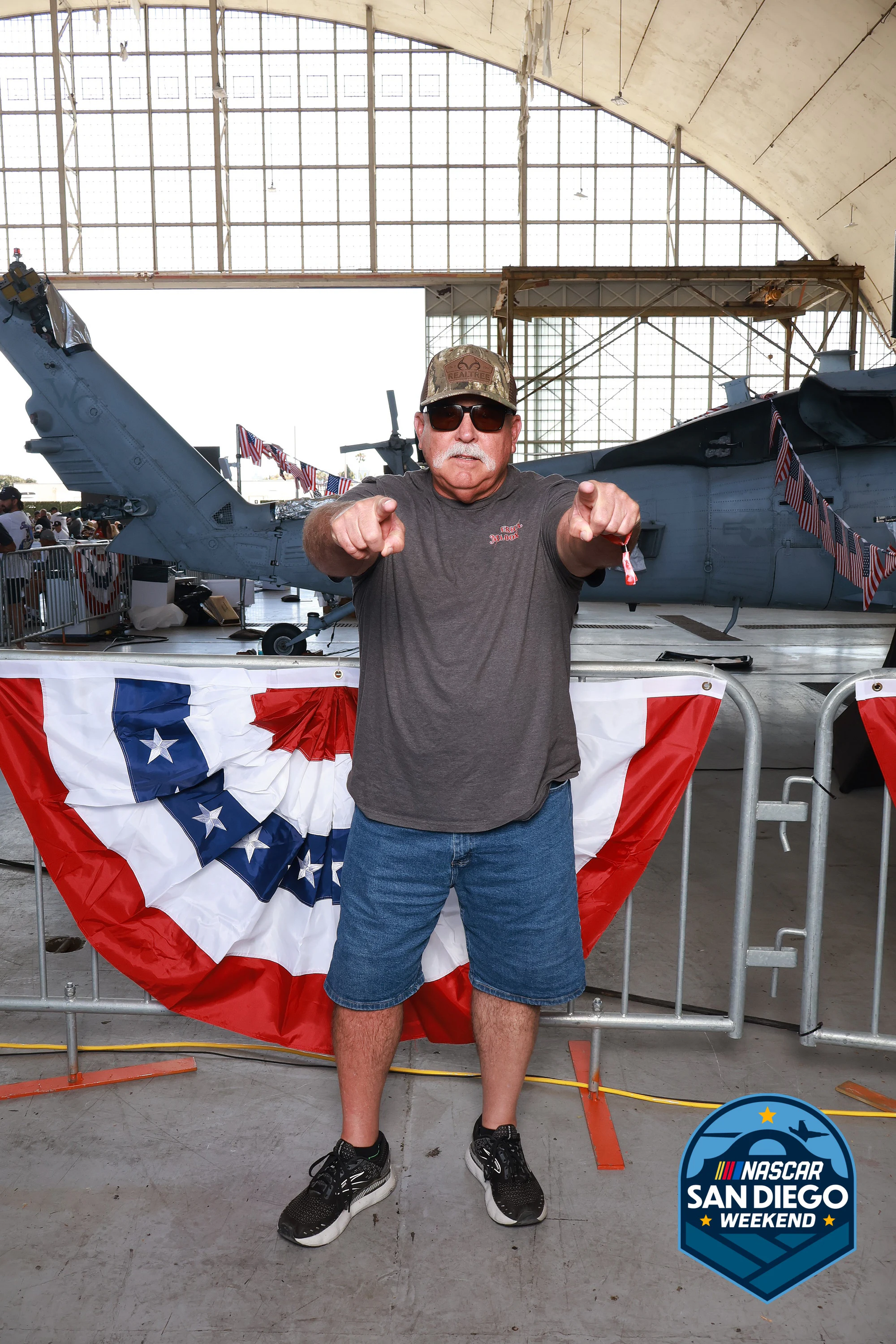A guest pointing both hands at the lens at NASCAR San Diego