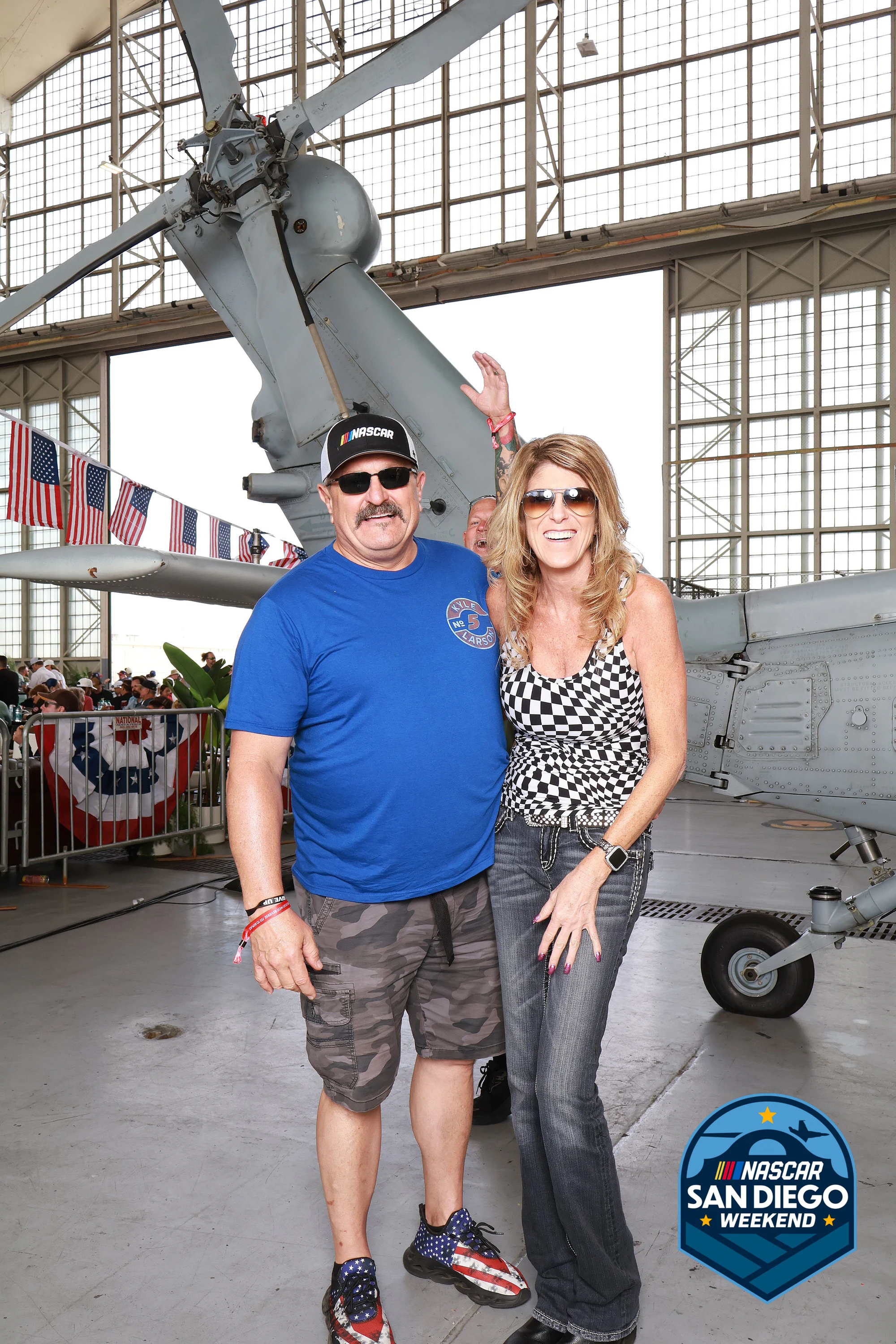 A couple, one in a checkered dress at NASCAR San Diego