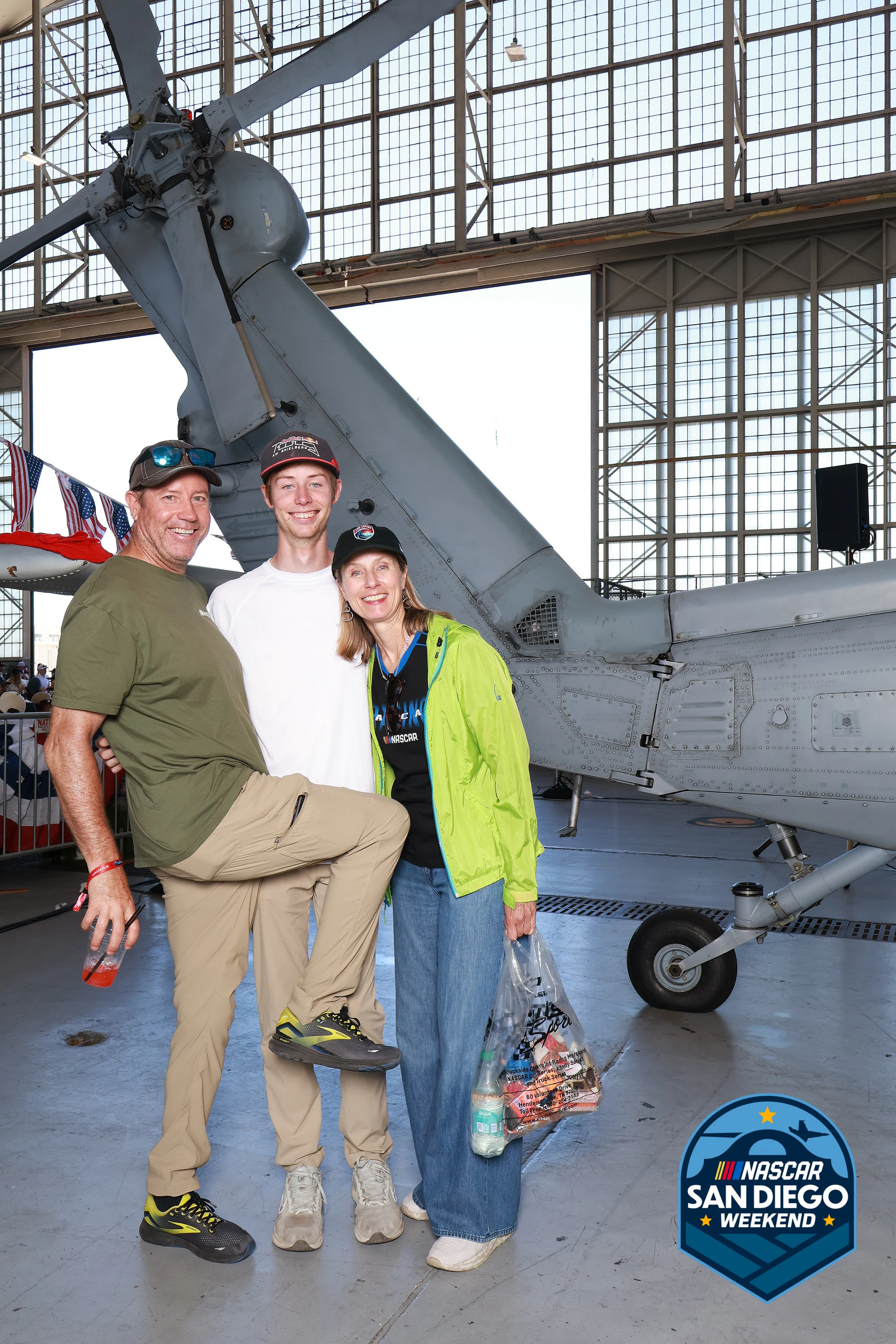 Four friends arm in arm under the jet tail at NASCAR San Diego