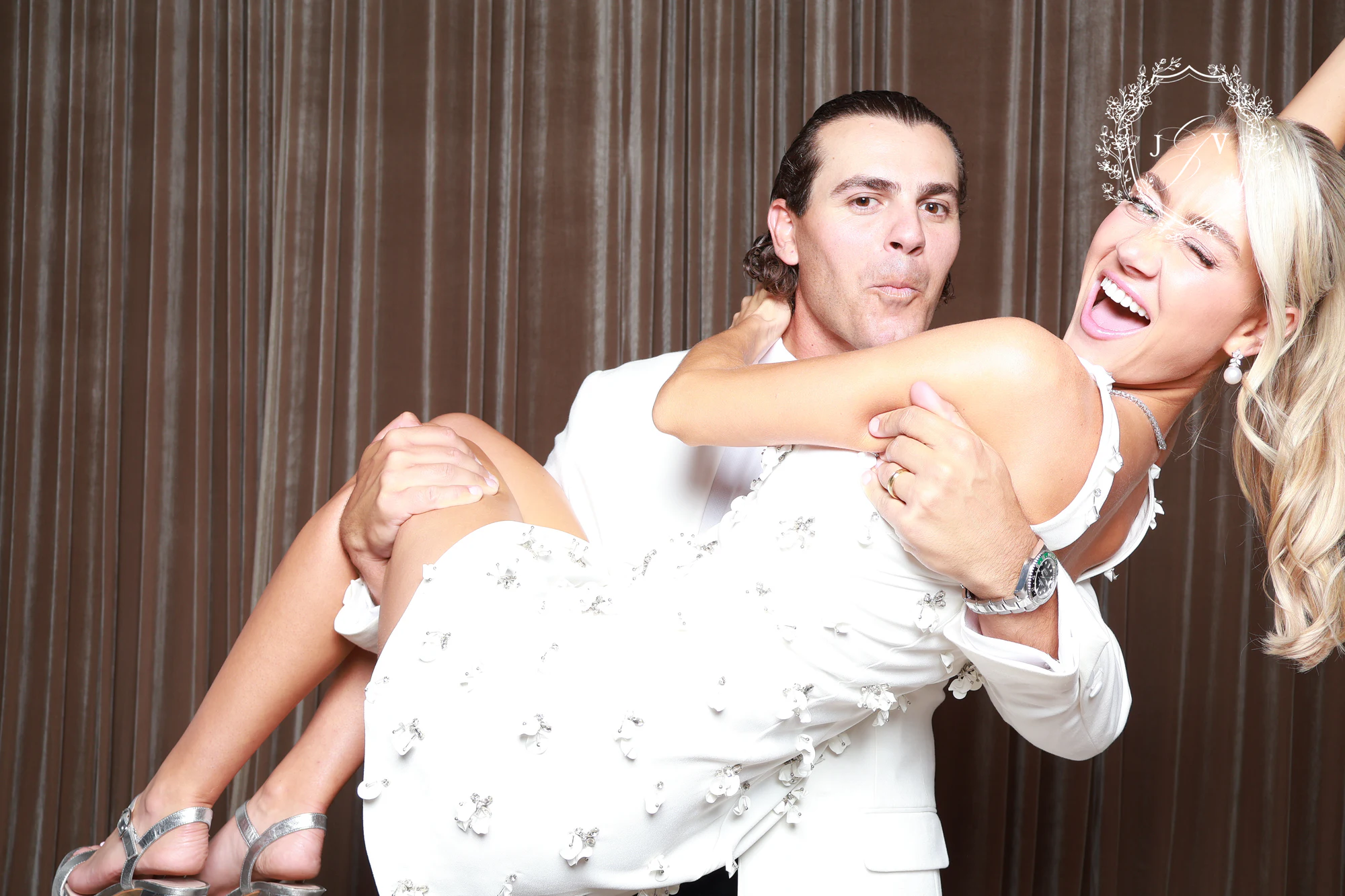 The groom lifting the bride in his arms, both laughing at Nash Gaurino Wedding