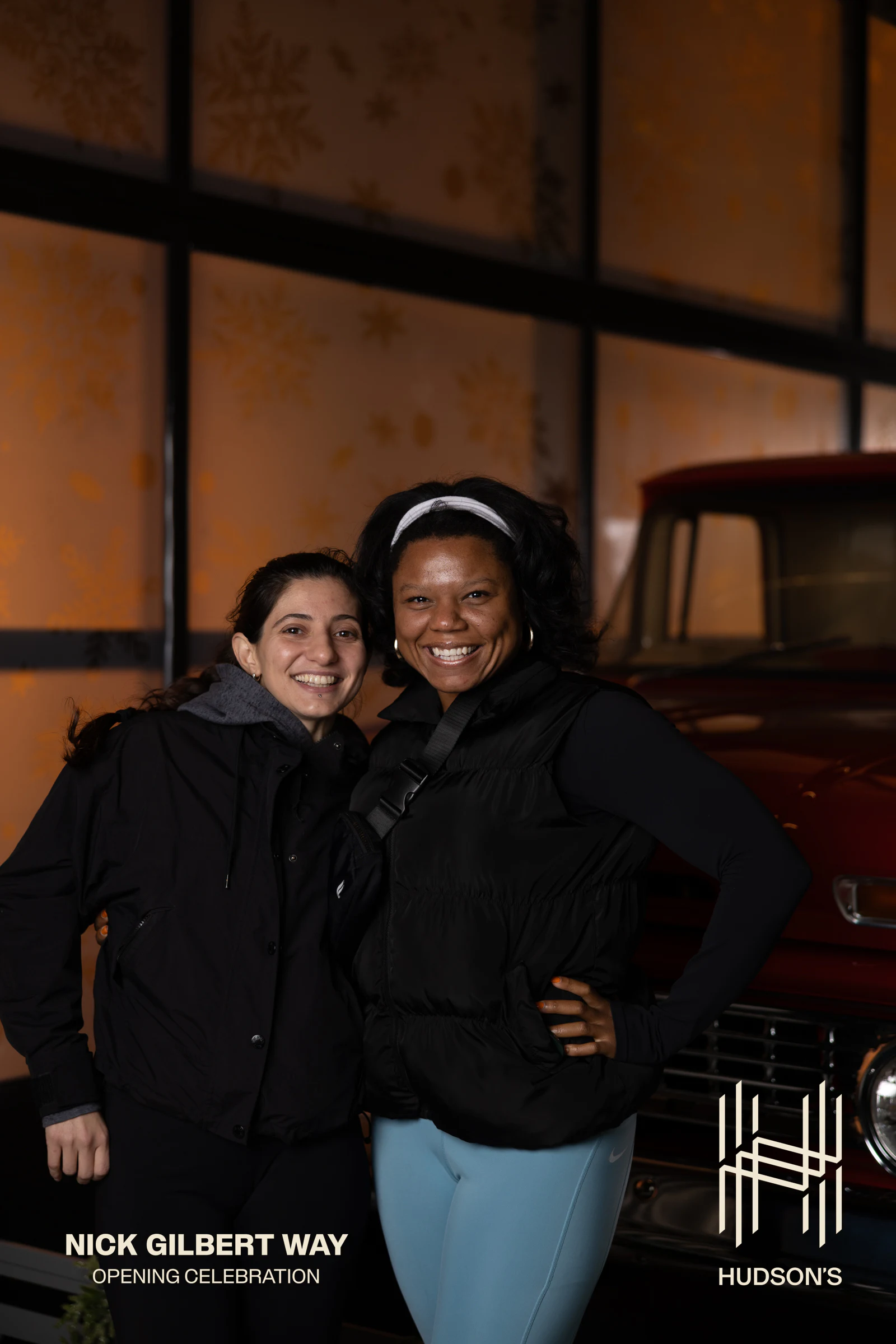 Two women arm in arm, both beaming at Nick Gilbert Way Opening Celebration