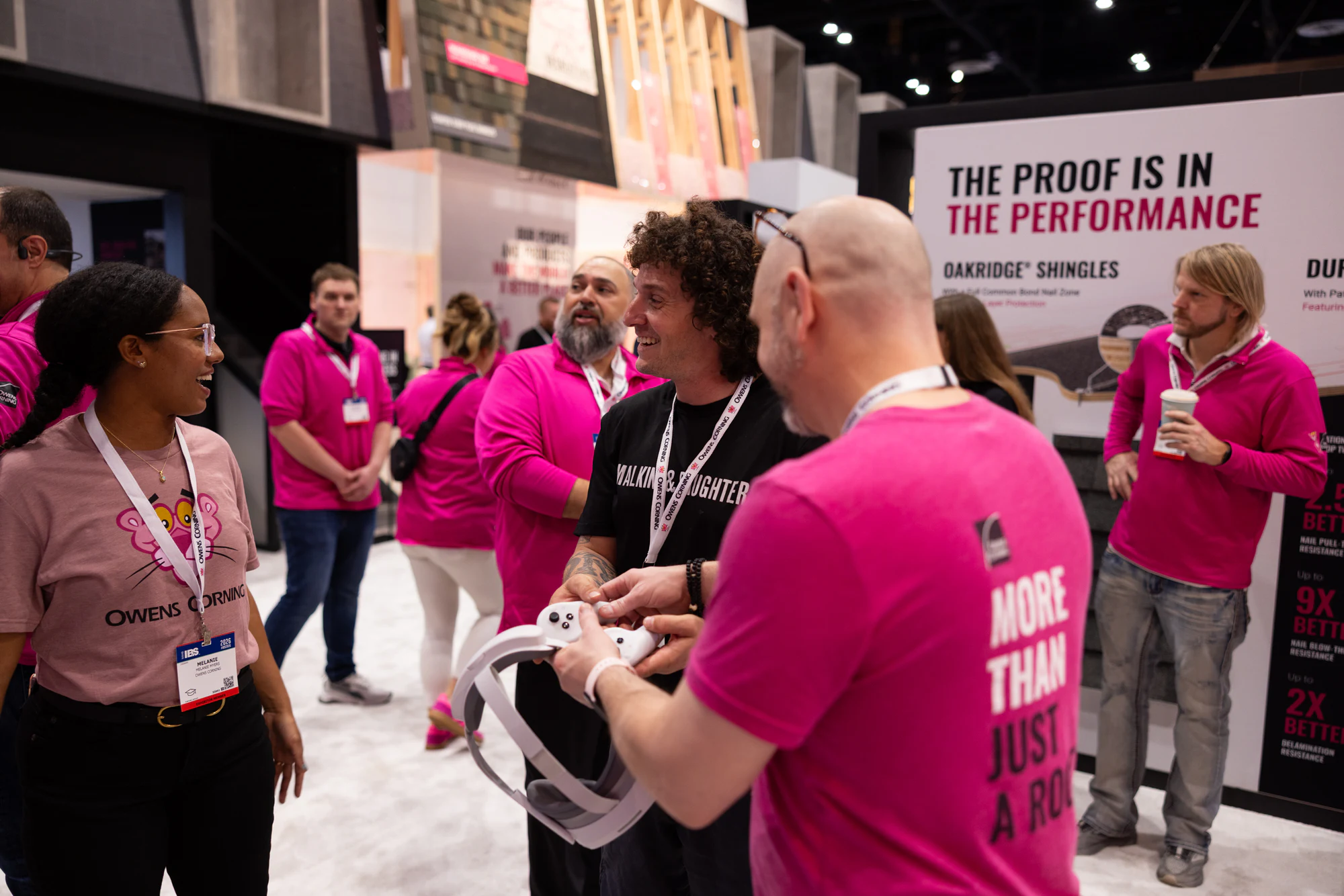 Two staff handing off the headset at Owens Corning at IBS 2026