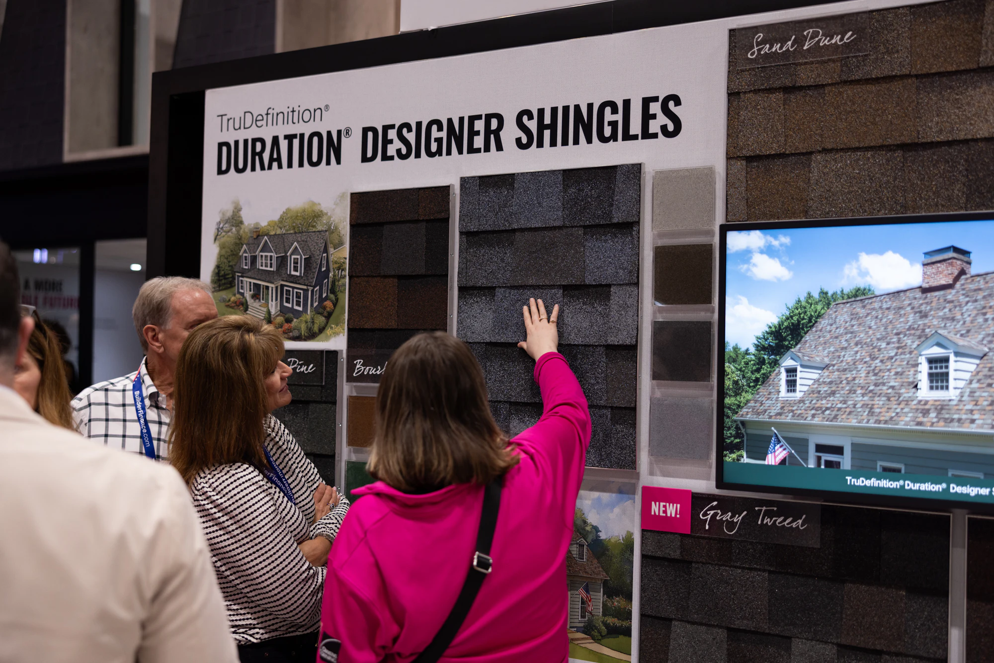 Guest reaching up into the Duration shingle wall at Owens Corning at IBS 2026