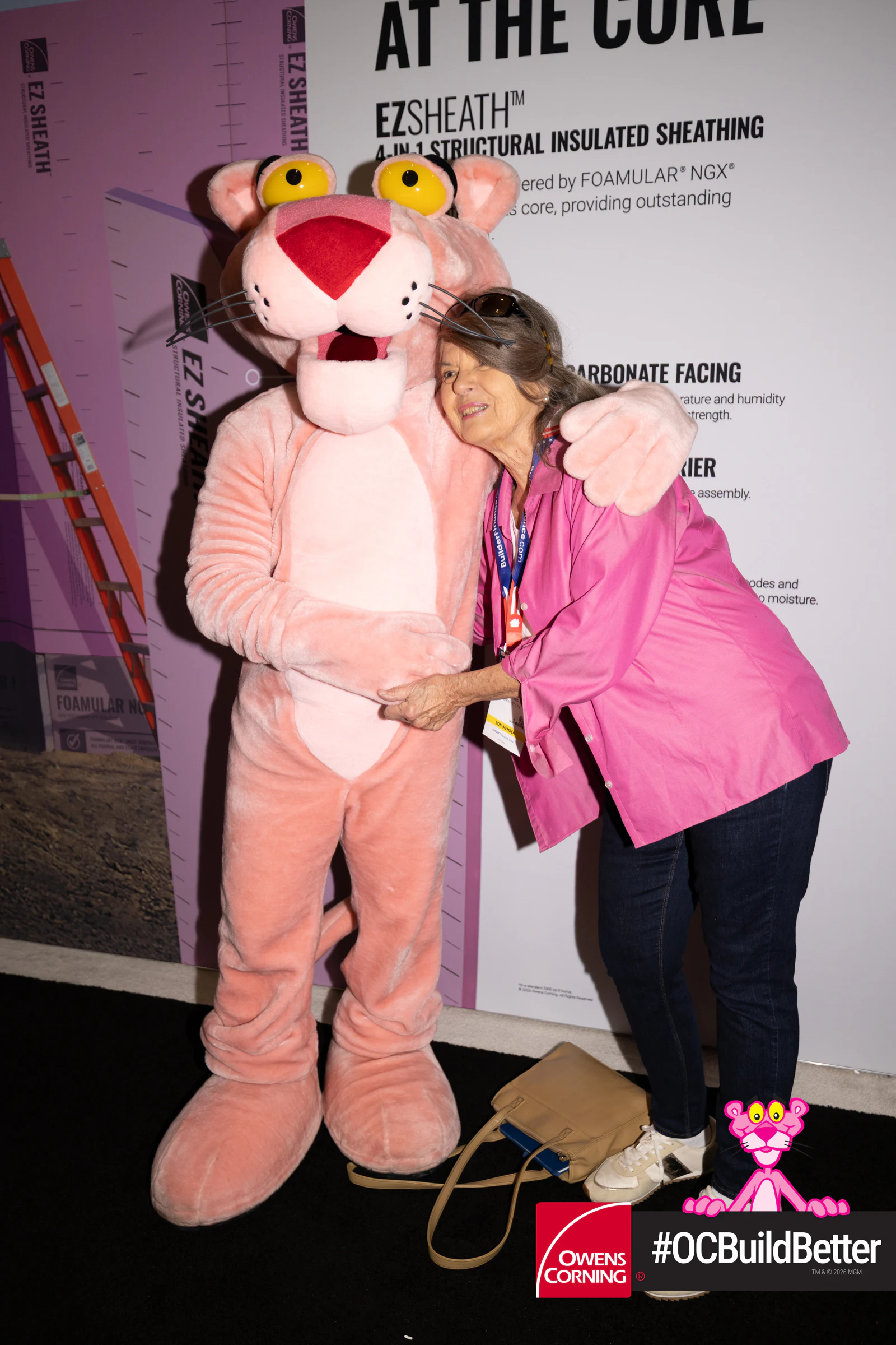 Woman hugging the Panther mid-laugh at Owens Corning at IBS 2026