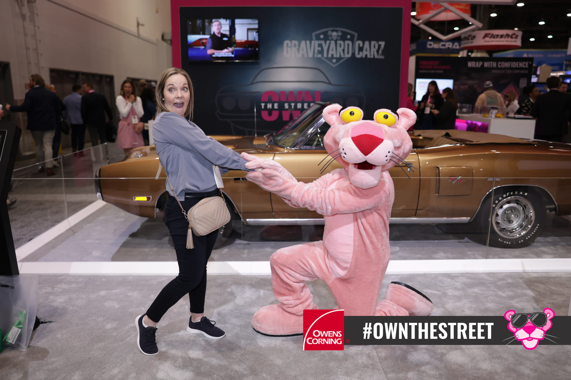 Guest striking a playful pose while the Pink Panther kneels at Owens Corning at IRE 2024