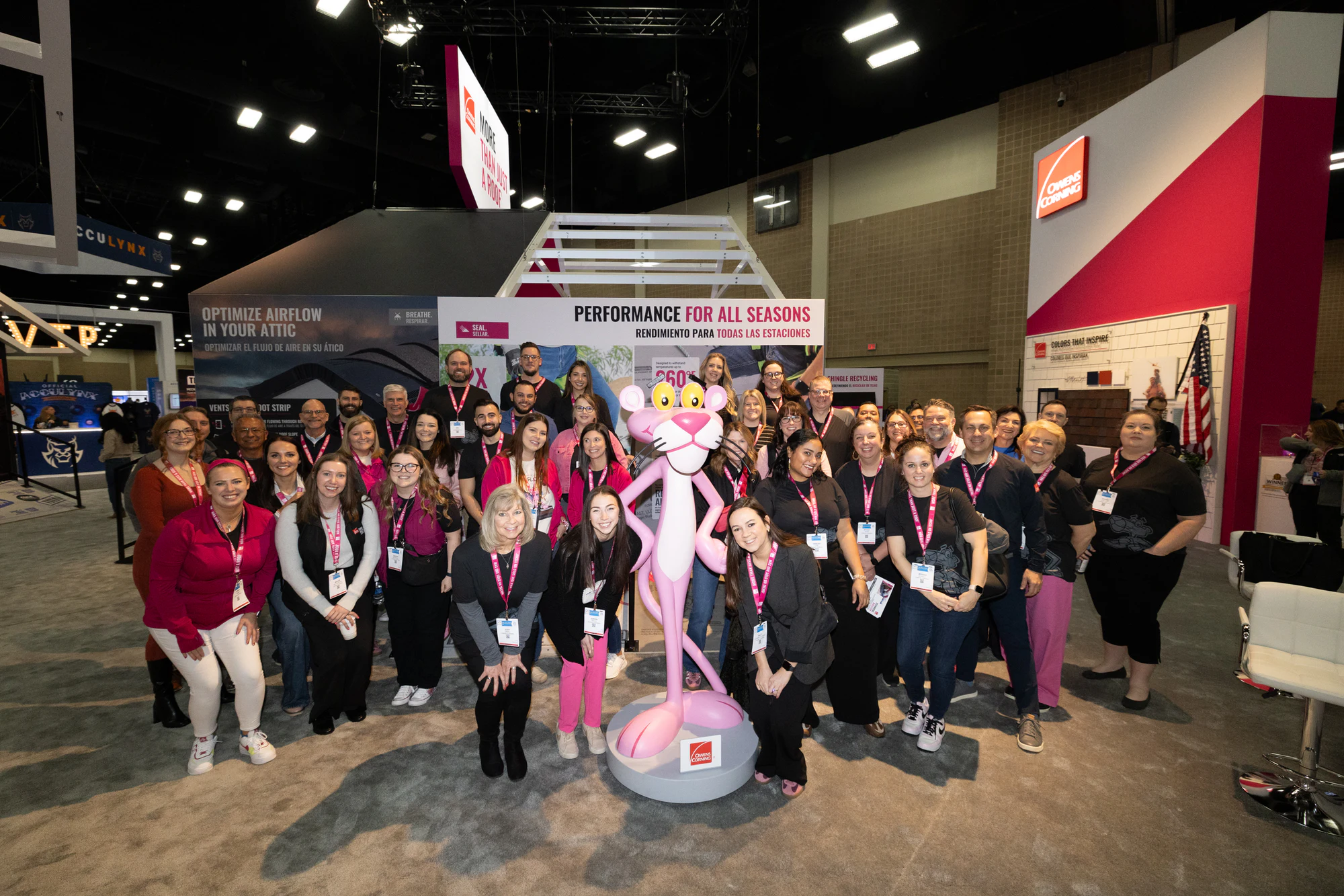 Owens Corning team gathered around the Pink Panther statue in the booth at Owens Corning at IRE 2025
