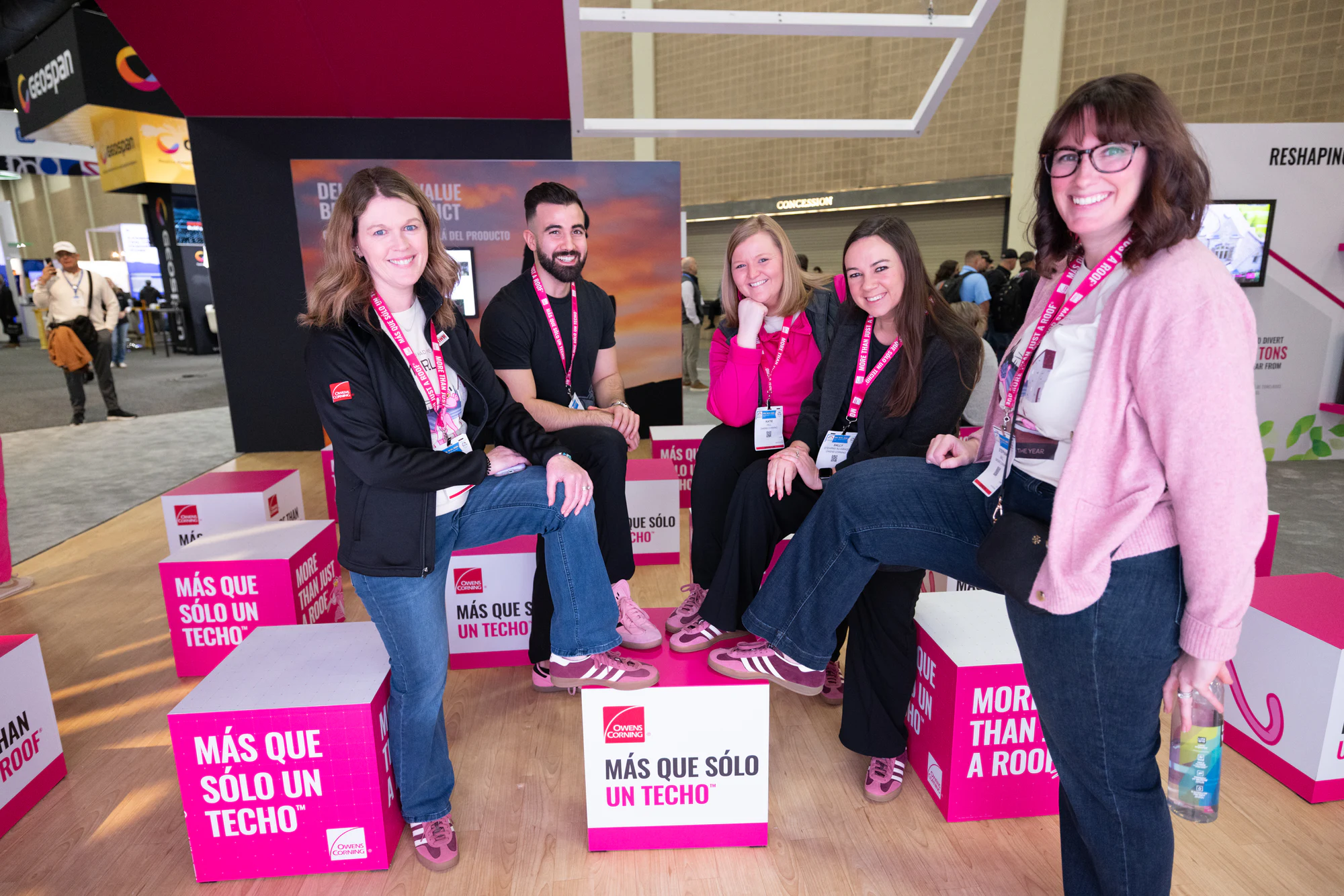 Four women from the team on the pink cubes at Owens Corning at IRE 2025