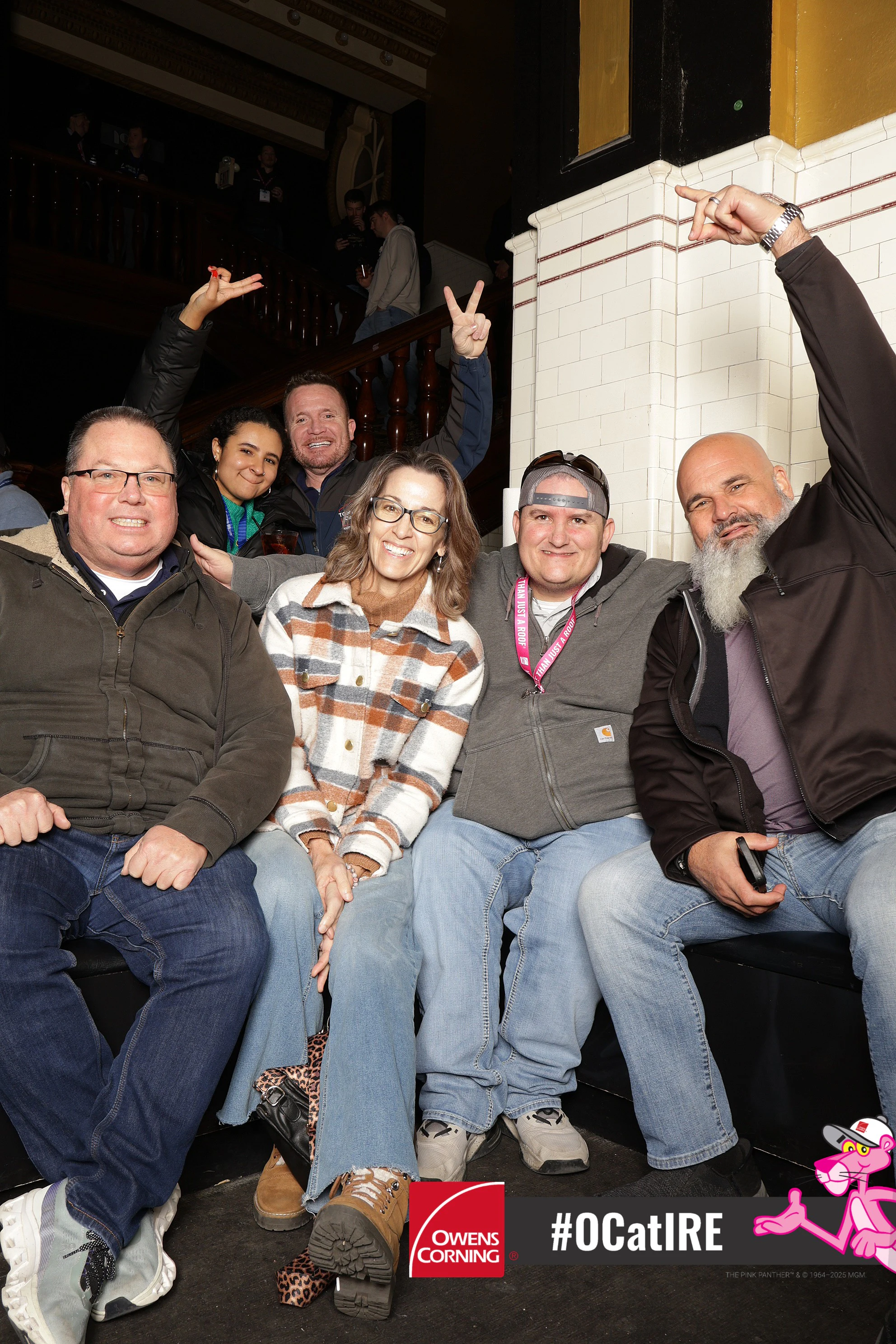 Five guests on the 1902 Venue bench, arms up at Owens Corning at IRE 2025