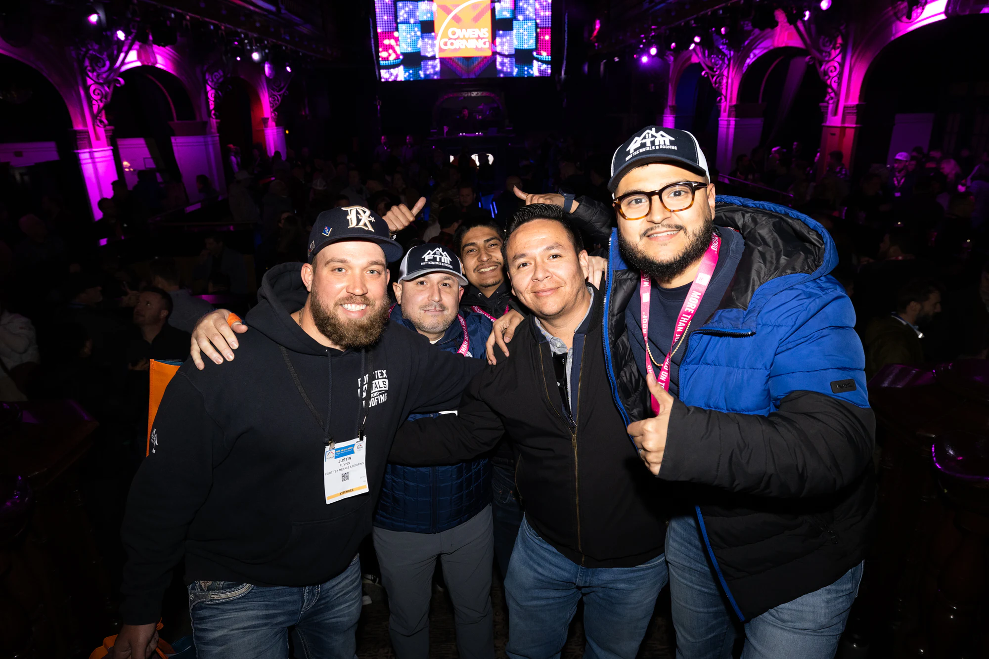 Four guys at the party, one throwing a peace sign at Owens Corning at IRE 2025