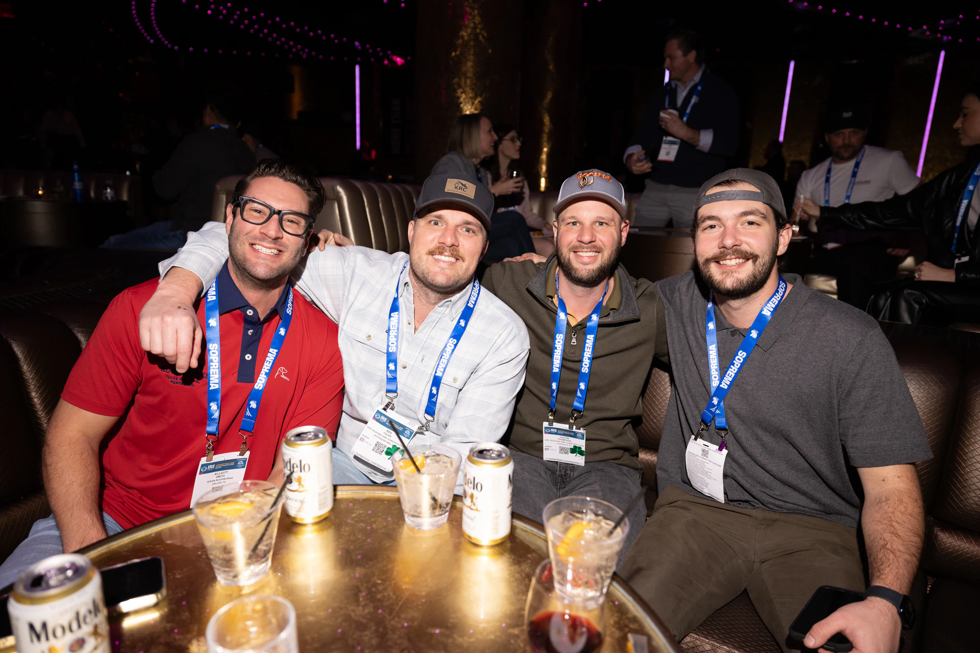 Five contractors around a booth table, all smiling at the lens at Owens Corning at IRE 2026