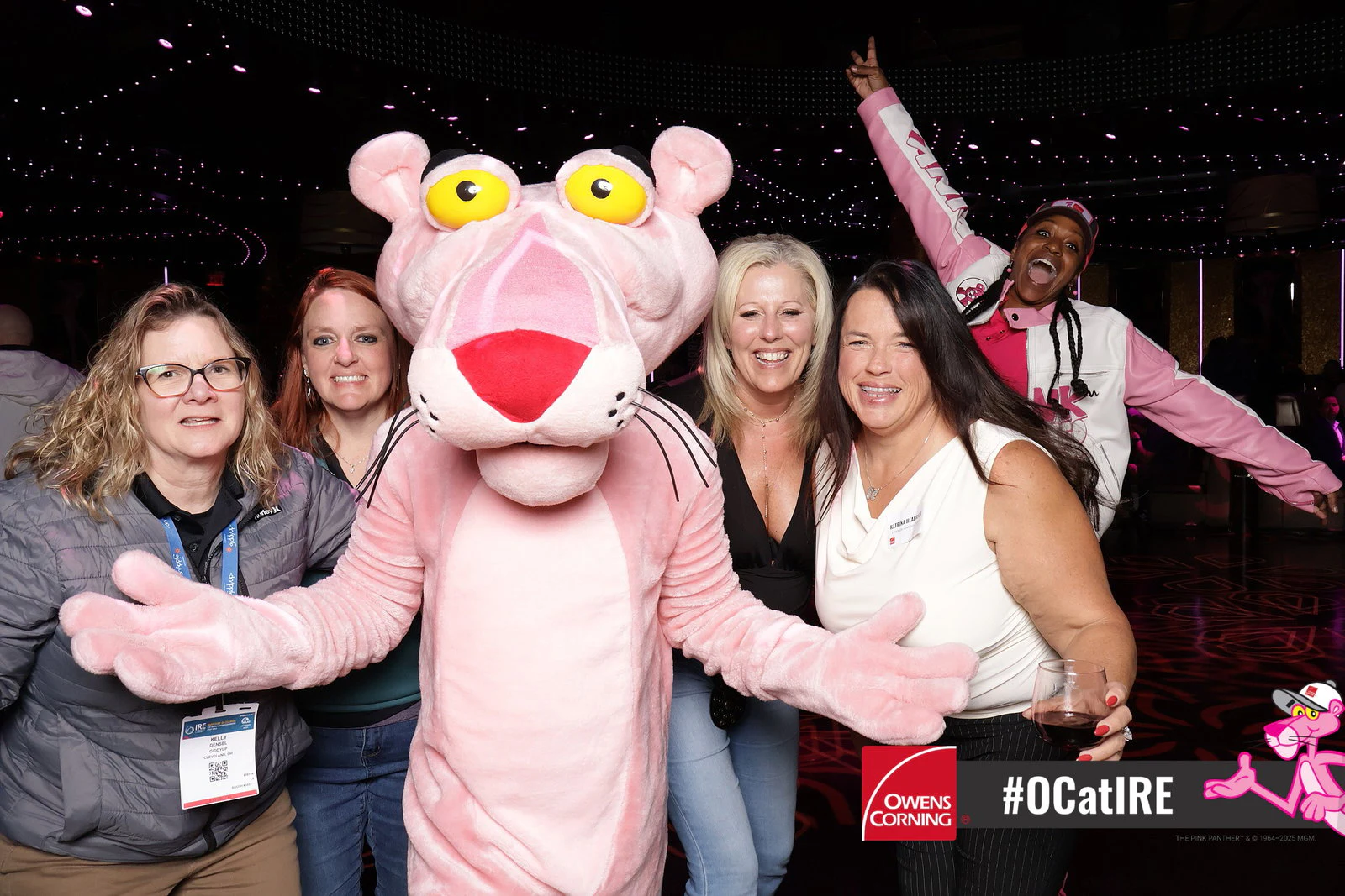 Panther front and center with a group, one guest with an arm up high at Owens Corning at IRE 2026