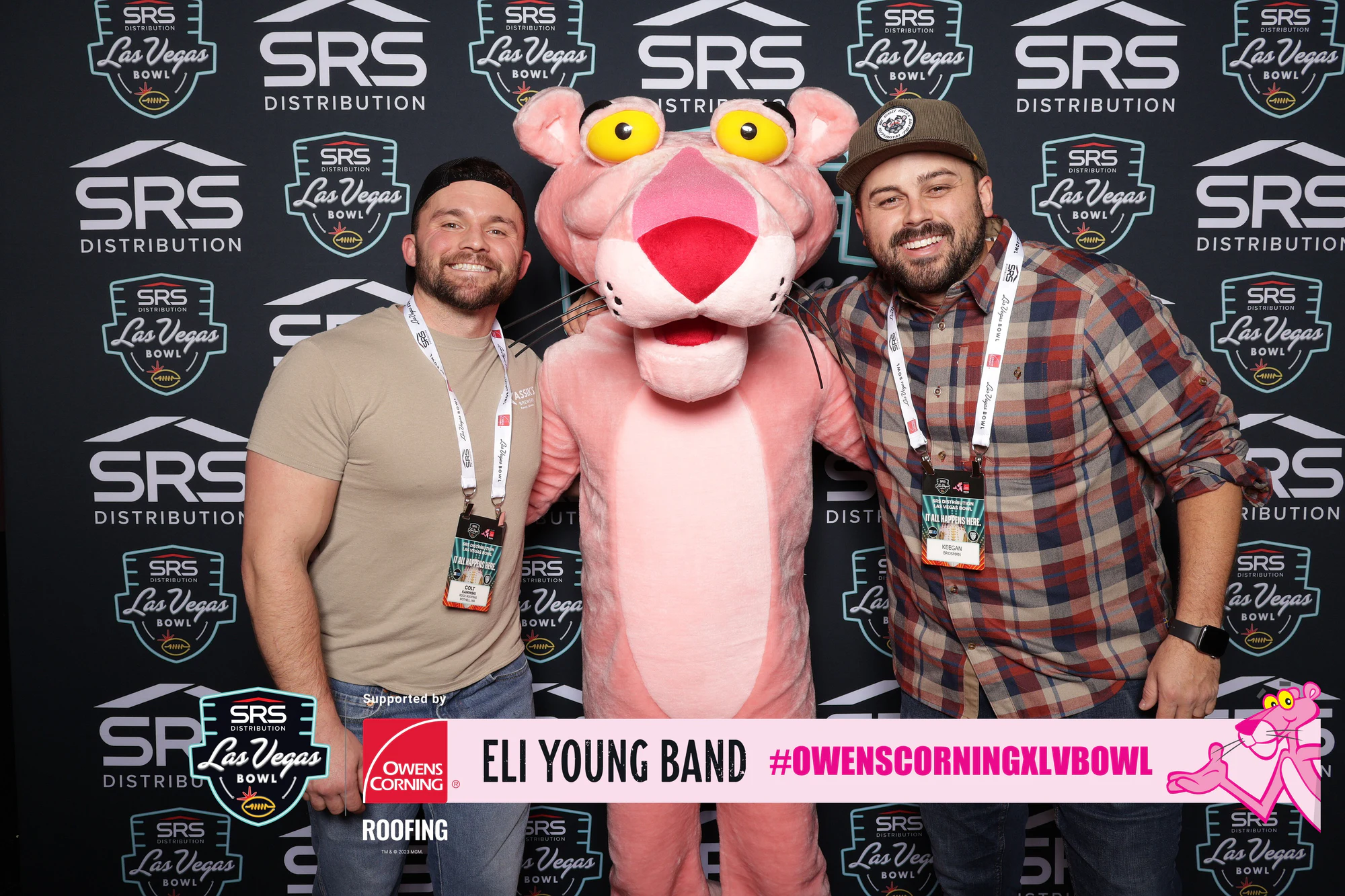 The Pink Panther between two guests in lanyards at Owens Corning at the 2023 Las Vegas Bowl