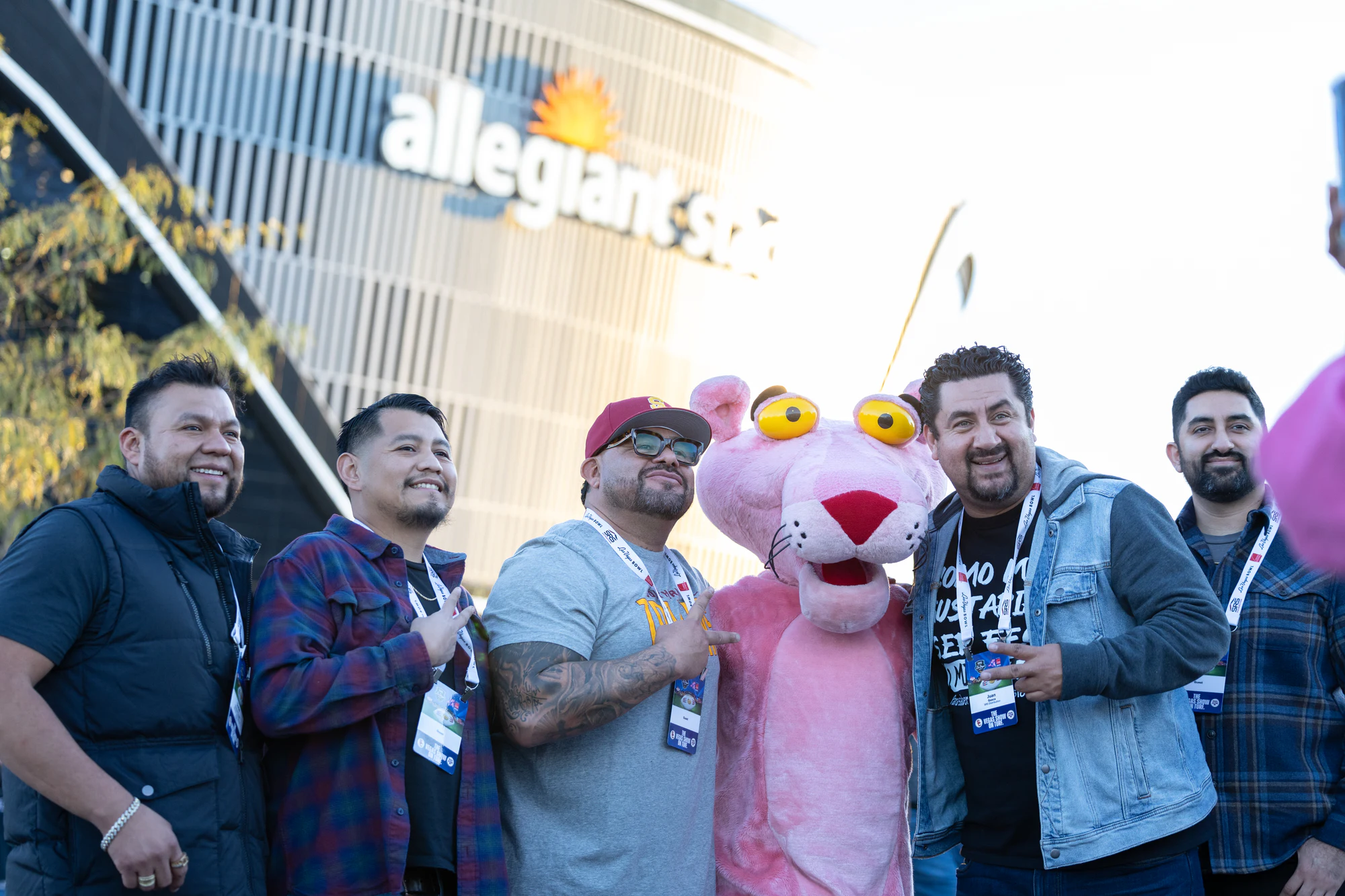 Six guys crowd around the Pink Panther under the Allegiant Stadium sign at Owens Corning at the 2024 Las Vegas Bowl