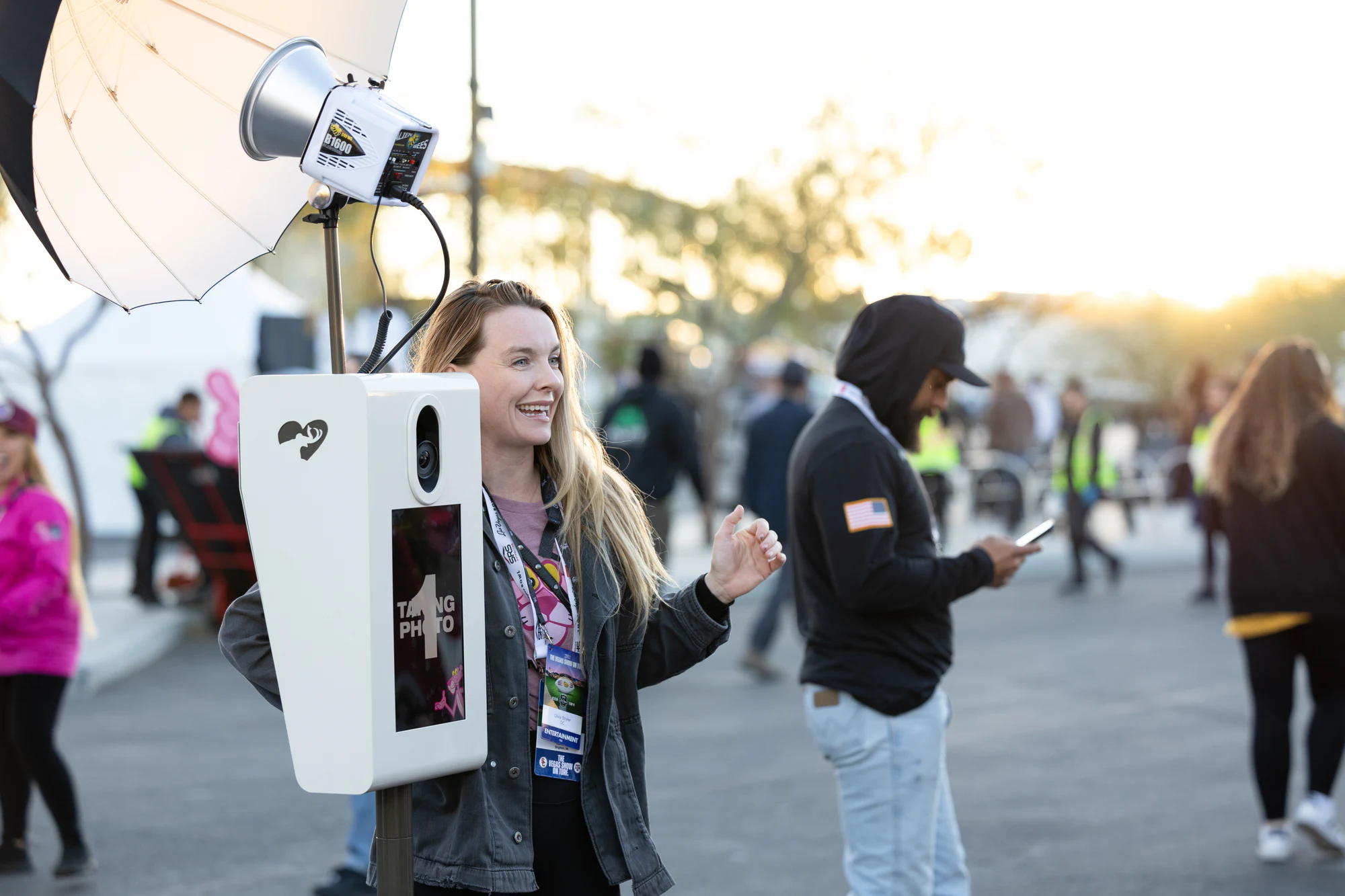 A crew member laughs beside the booth kiosk mid-countdown, softbox overhead at Fan Fest at Owens Corning at the 2024 Las Vegas Bowl