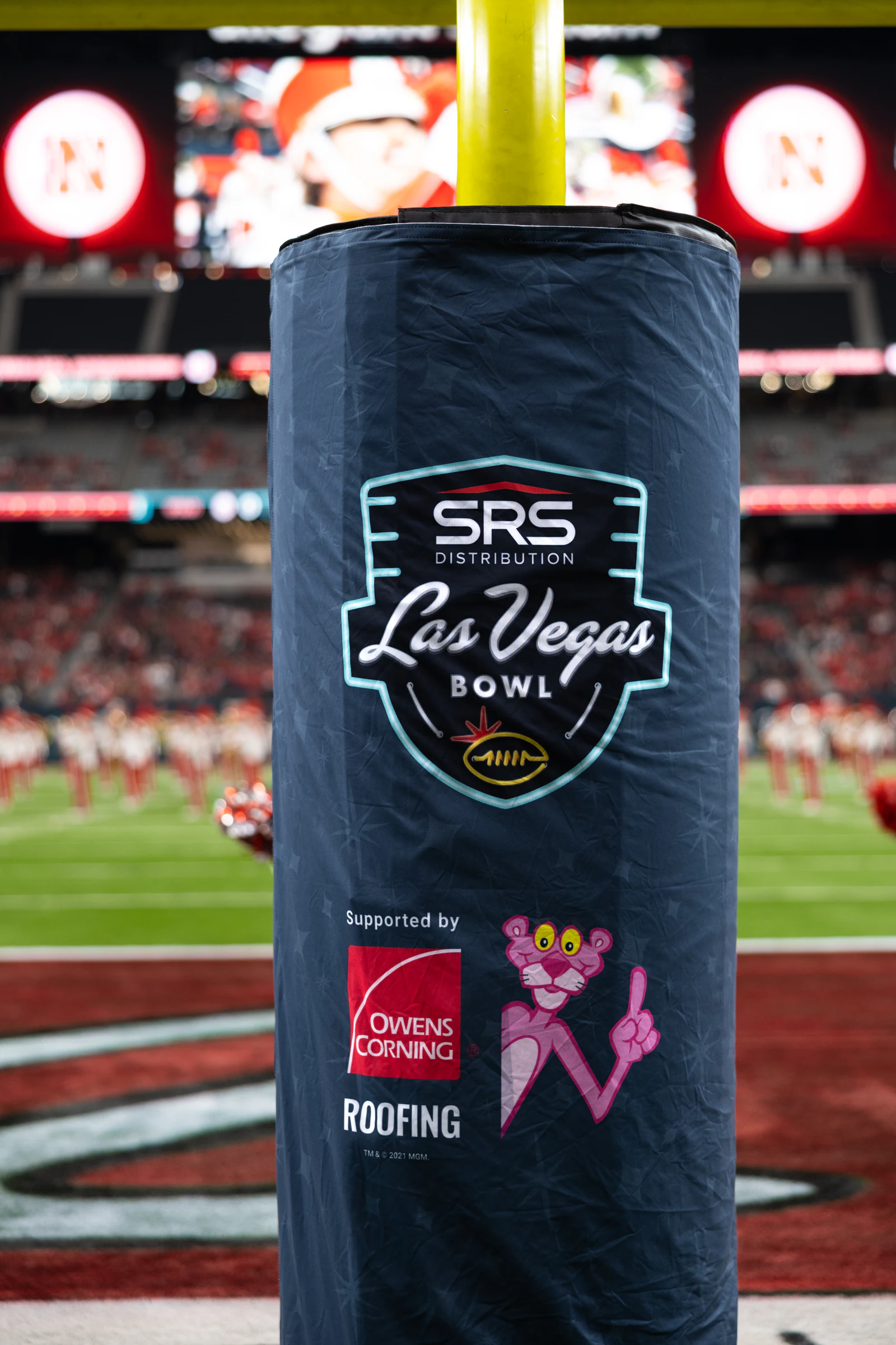 Goalpost pad carrying the Las Vegas Bowl, Owens Corning Roofing and Pink Panther logos, field behind at Owens Corning at the 2025 Las Vegas Bowl