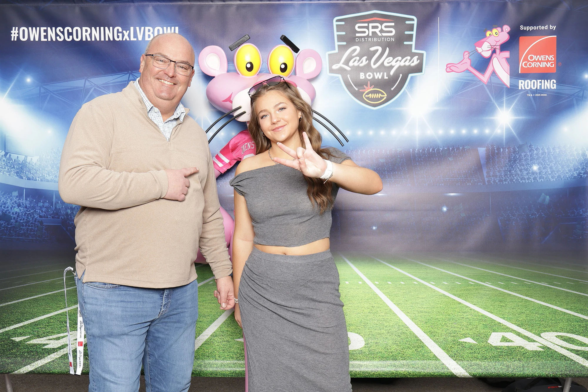The two side by side again, he points and she throws a hand sign at Owens Corning at the 2025 Las Vegas Bowl