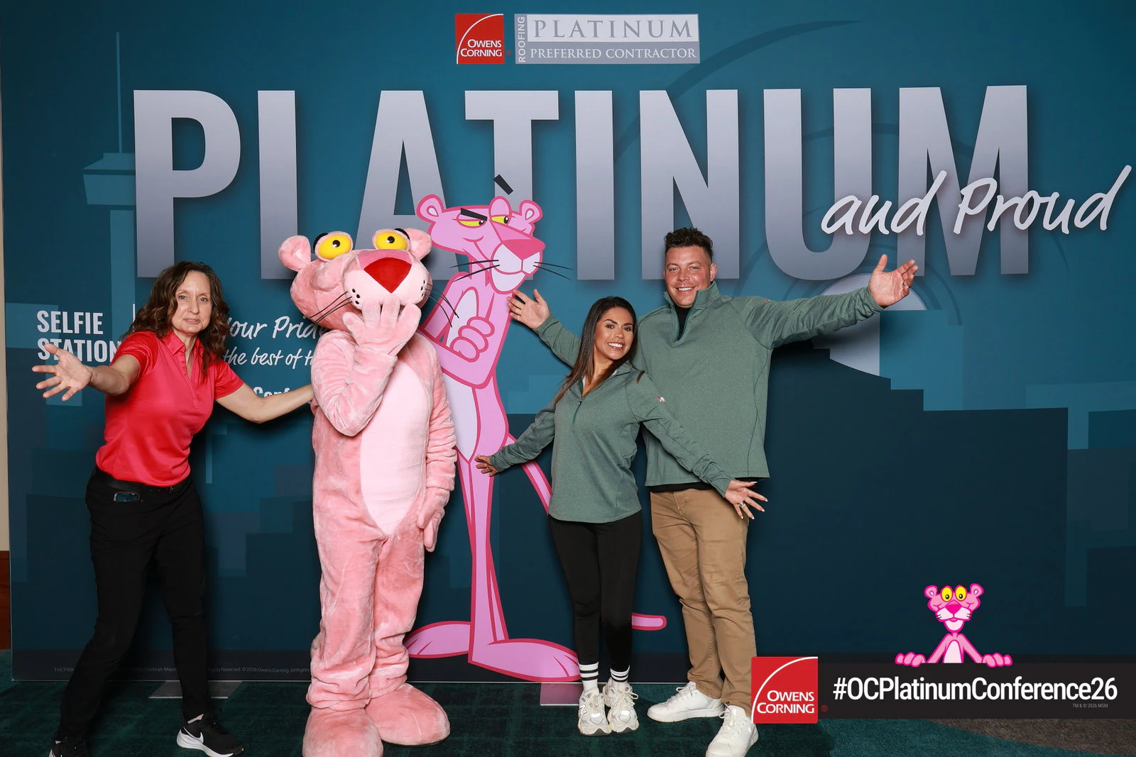 A costumed pink panther mascot with three guests, arms out at Owens Corning Platinum Conference 2026