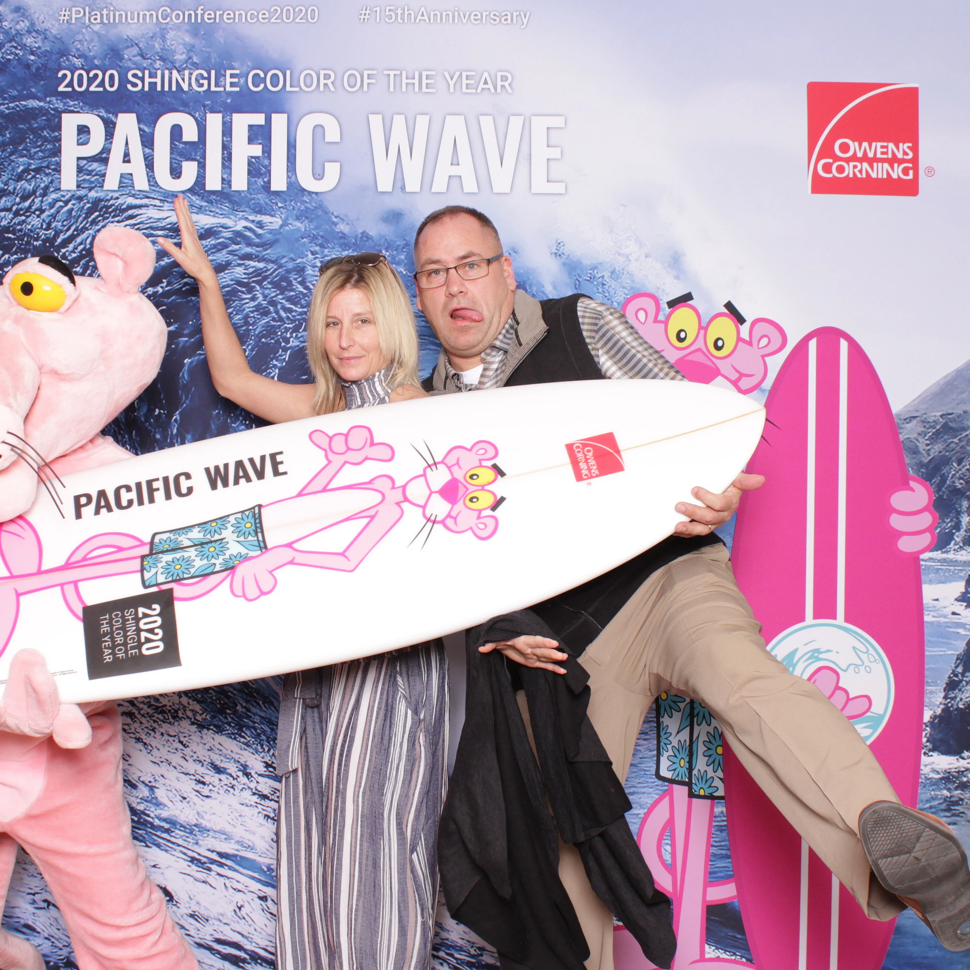 Three with arms around the character, all laughing at Owens Corning Platinum Conference