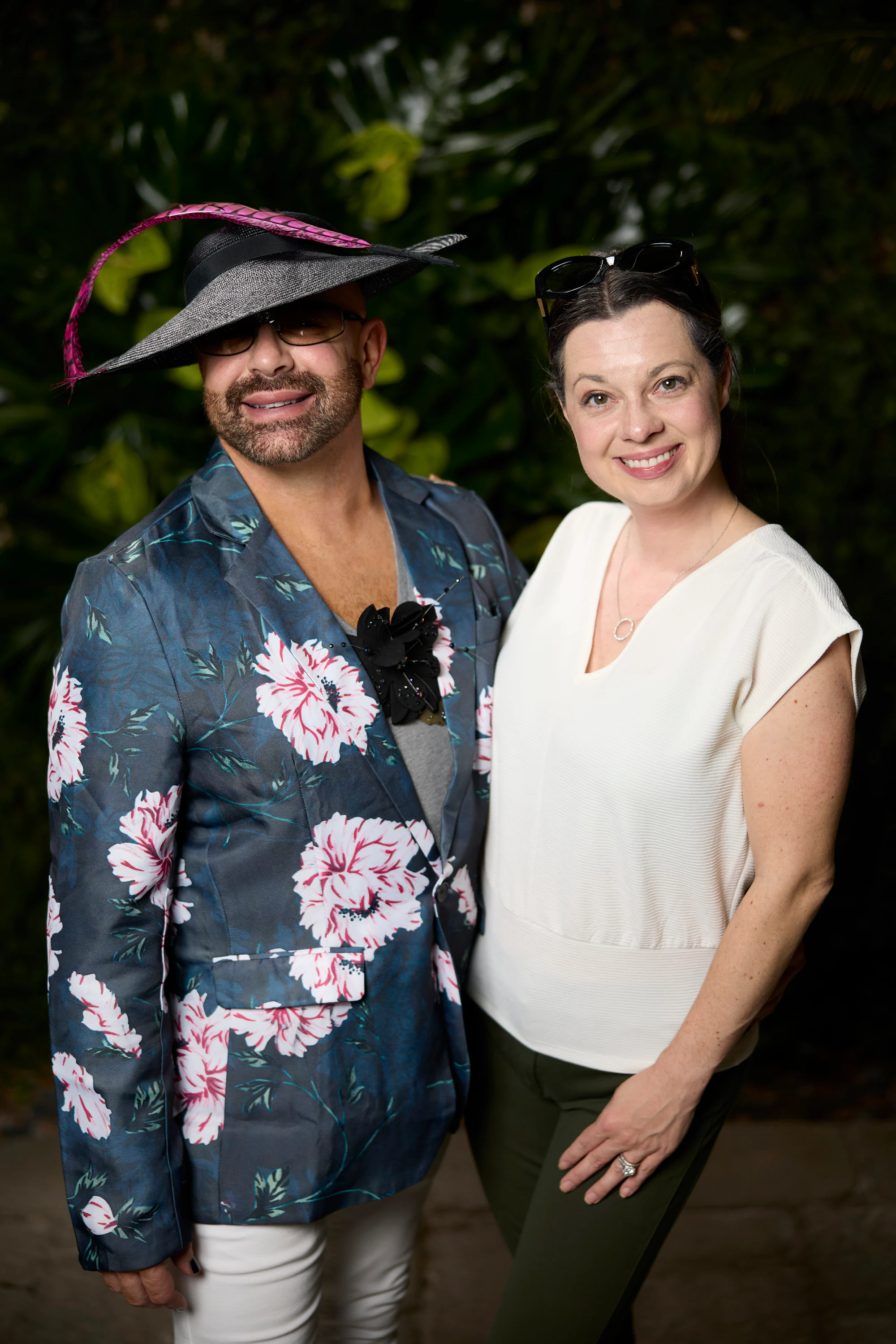 A guest in a wide-brimmed hat and a floral jacket beside a guest in white at the Planterra Open House