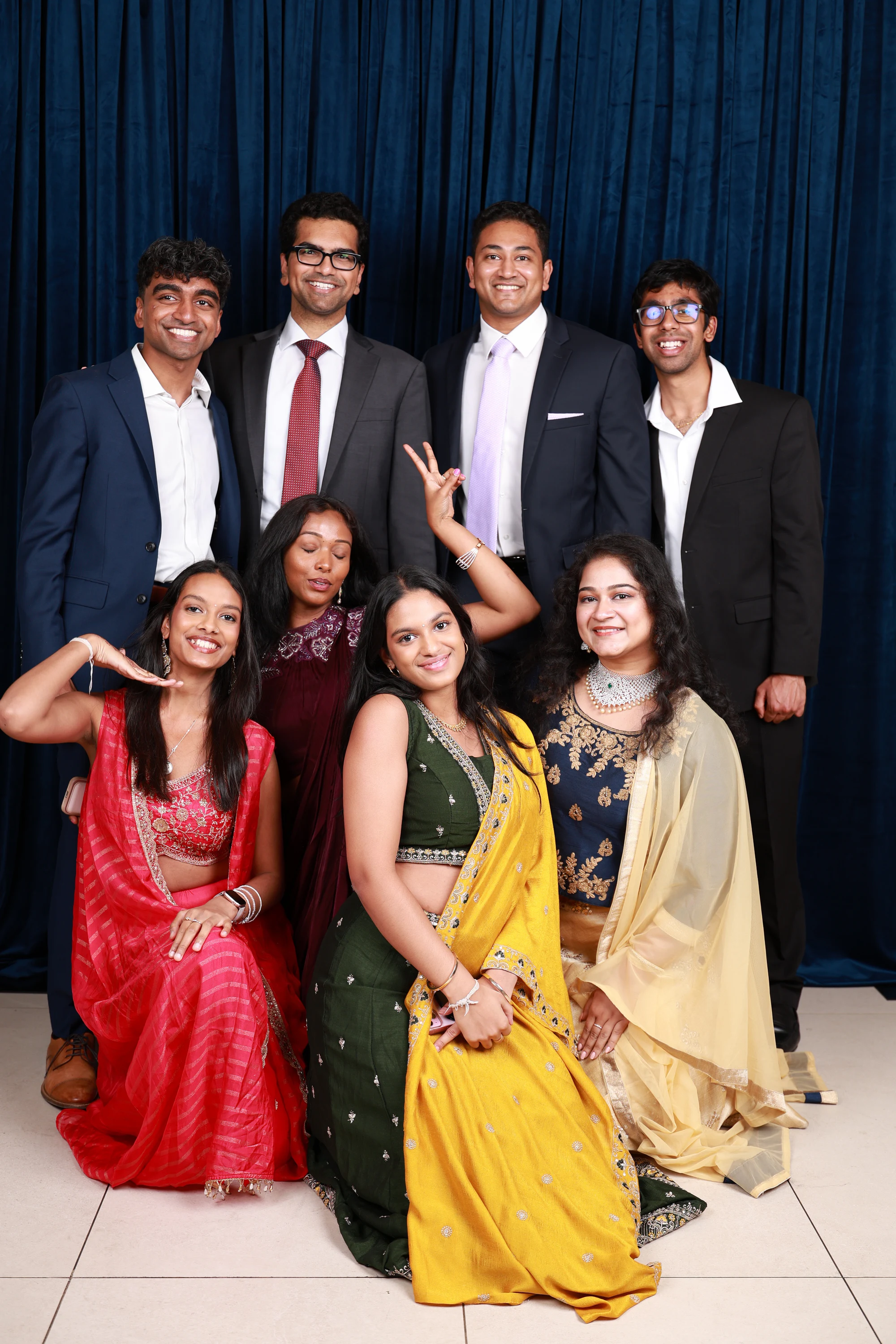 Big group of young guests in bright colors, standing and seated at Ramya + Sreehari