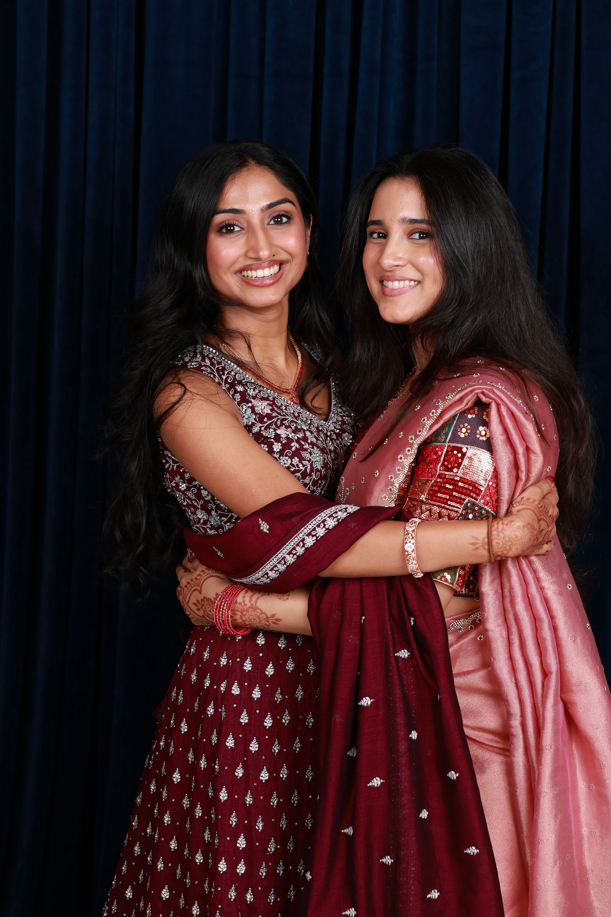 The same pair in a hug, both smiling at the camera at Ramya + Sreehari