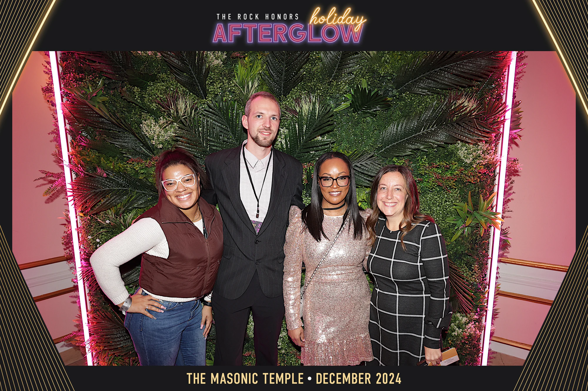 Four guests at the palm wall between two pink neon bars, in the AfterGlow frame at Rock Honors AfterGlow