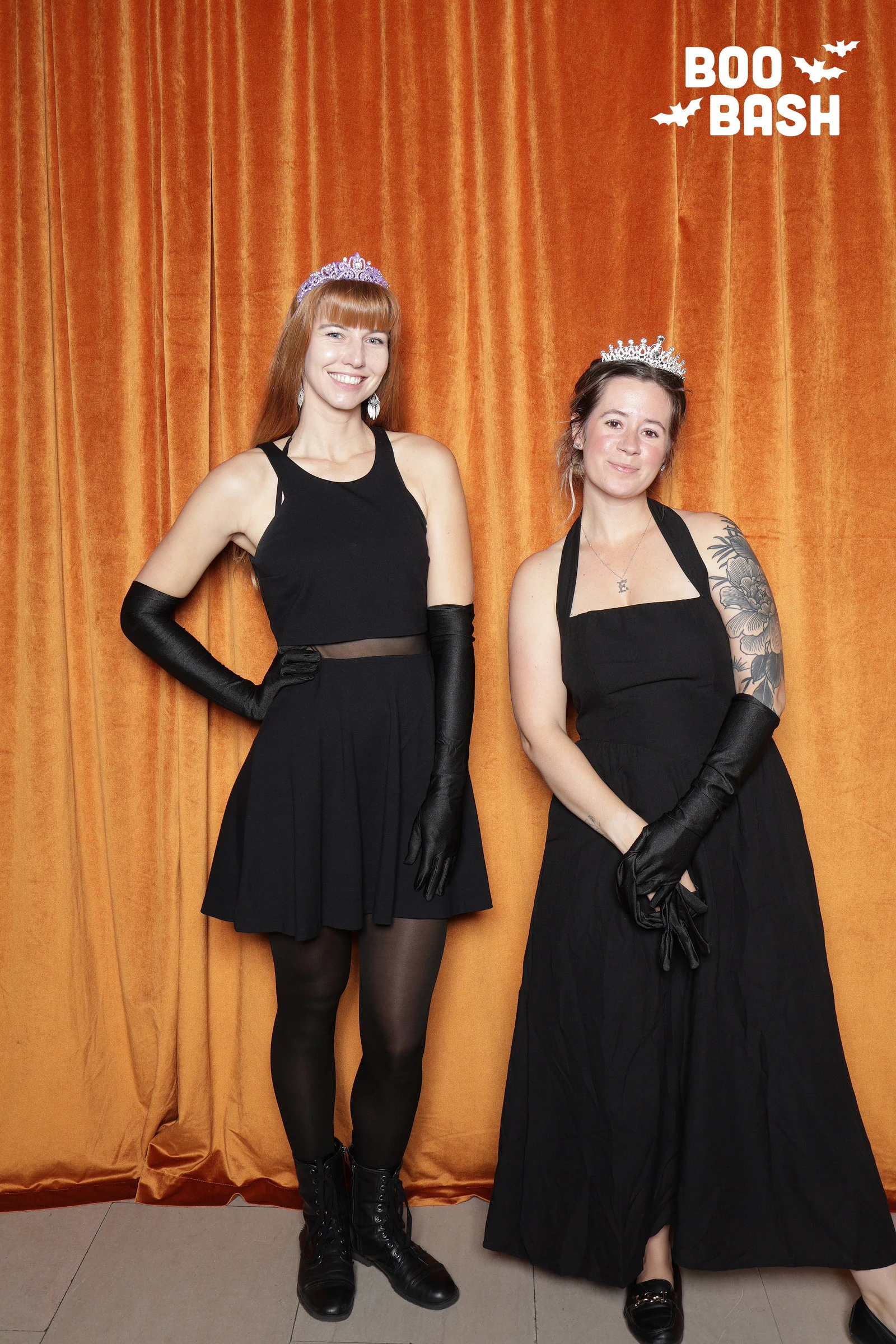 Two women in black dresses, long black gloves and tiaras at Rocket Boo Bash