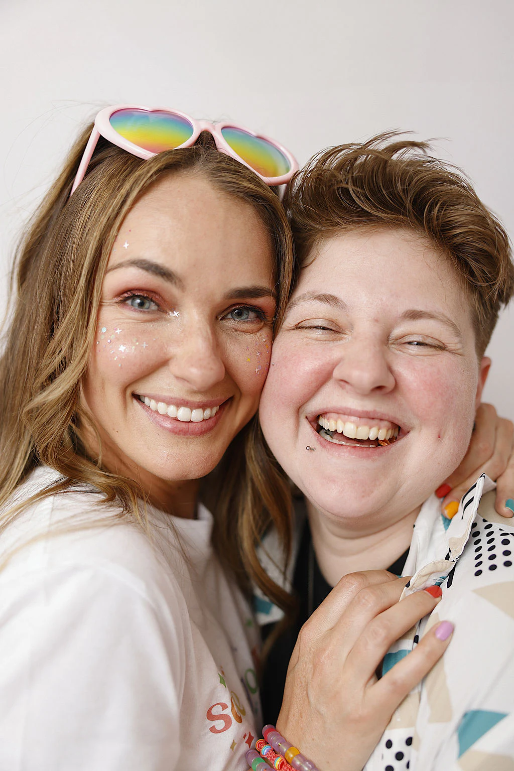 Two friends laughing, faces close at My Chosen Family Portraits at Motor City Pride 2025