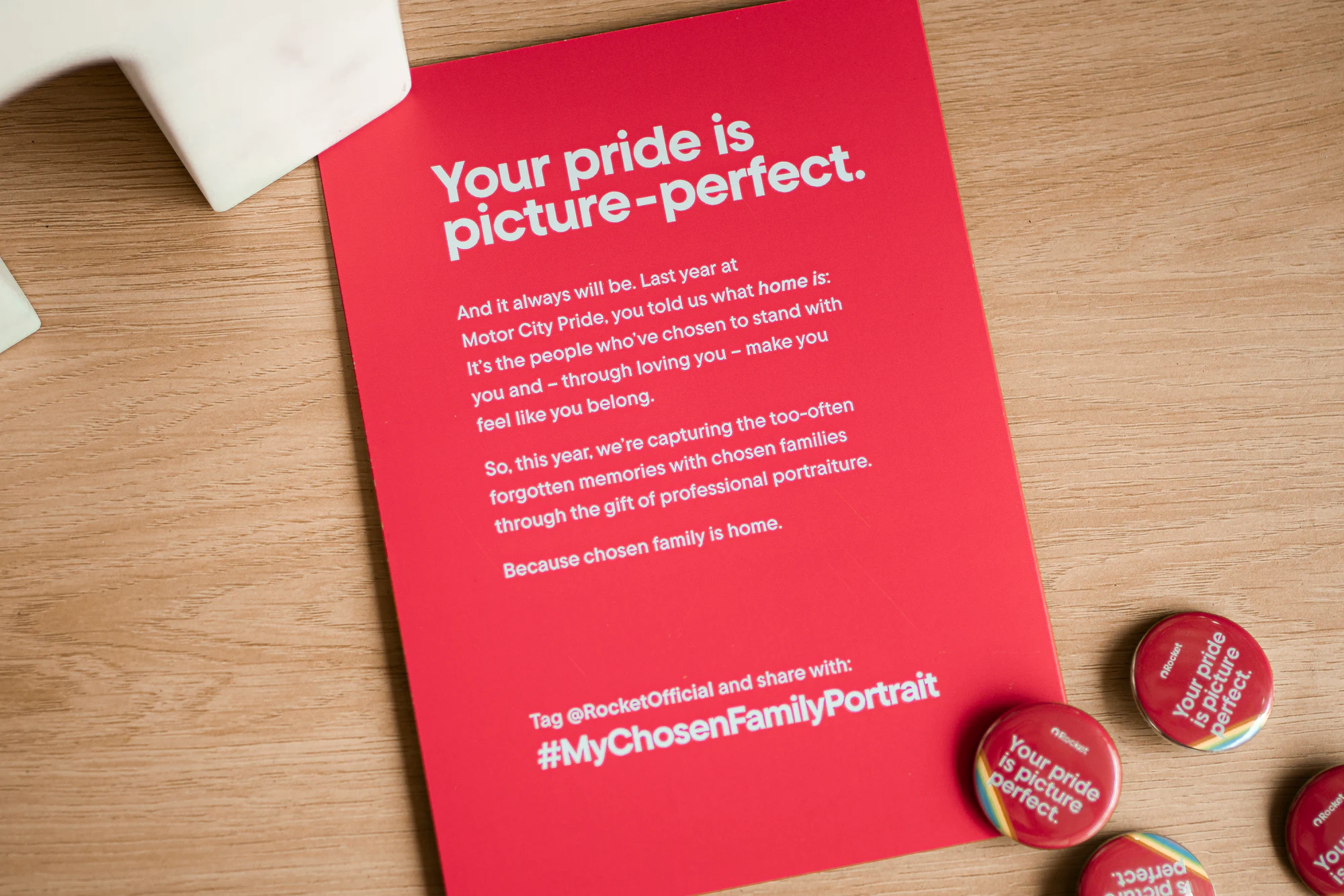 Printed card and buttons: “Your pride is picture-perfect” at My Chosen Family Portraits at Motor City Pride 2025