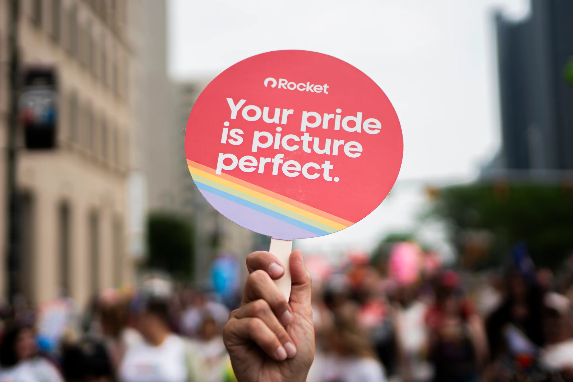 “Your pride is picture perfect” sign over the Pride crowd at My Chosen Family Portraits at Motor City Pride 2025