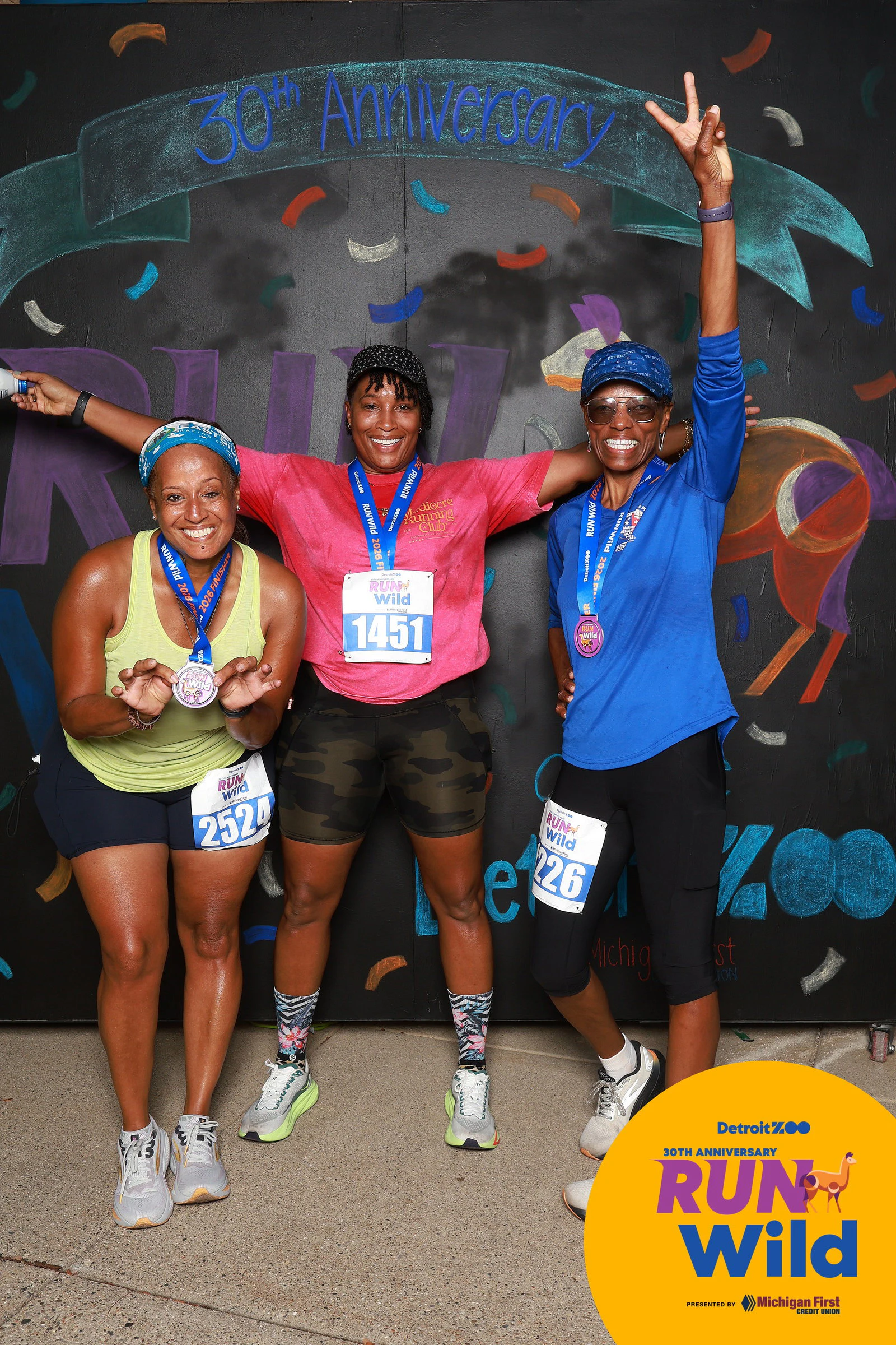 Three runners mid-cheer at Run Wild at the Detroit Zoo