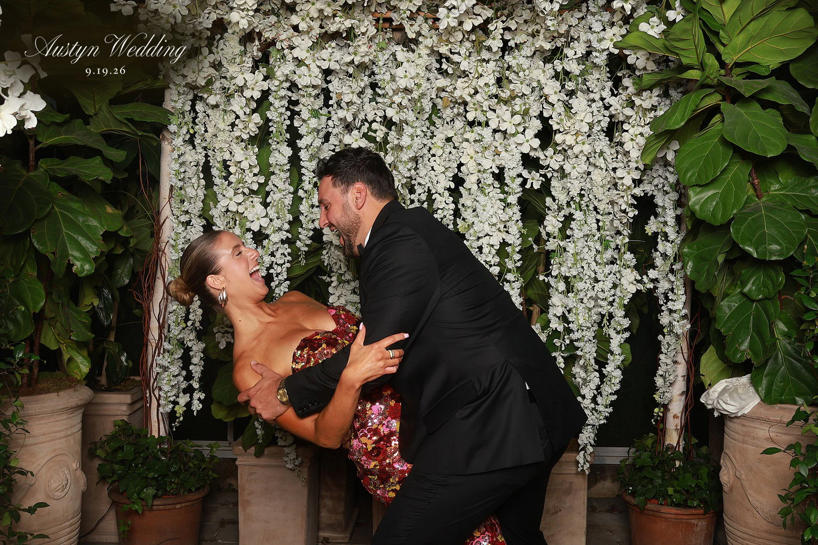 A couple in a playful dip, both grinning, at Ryley + Lauren at Planterra Conservatory