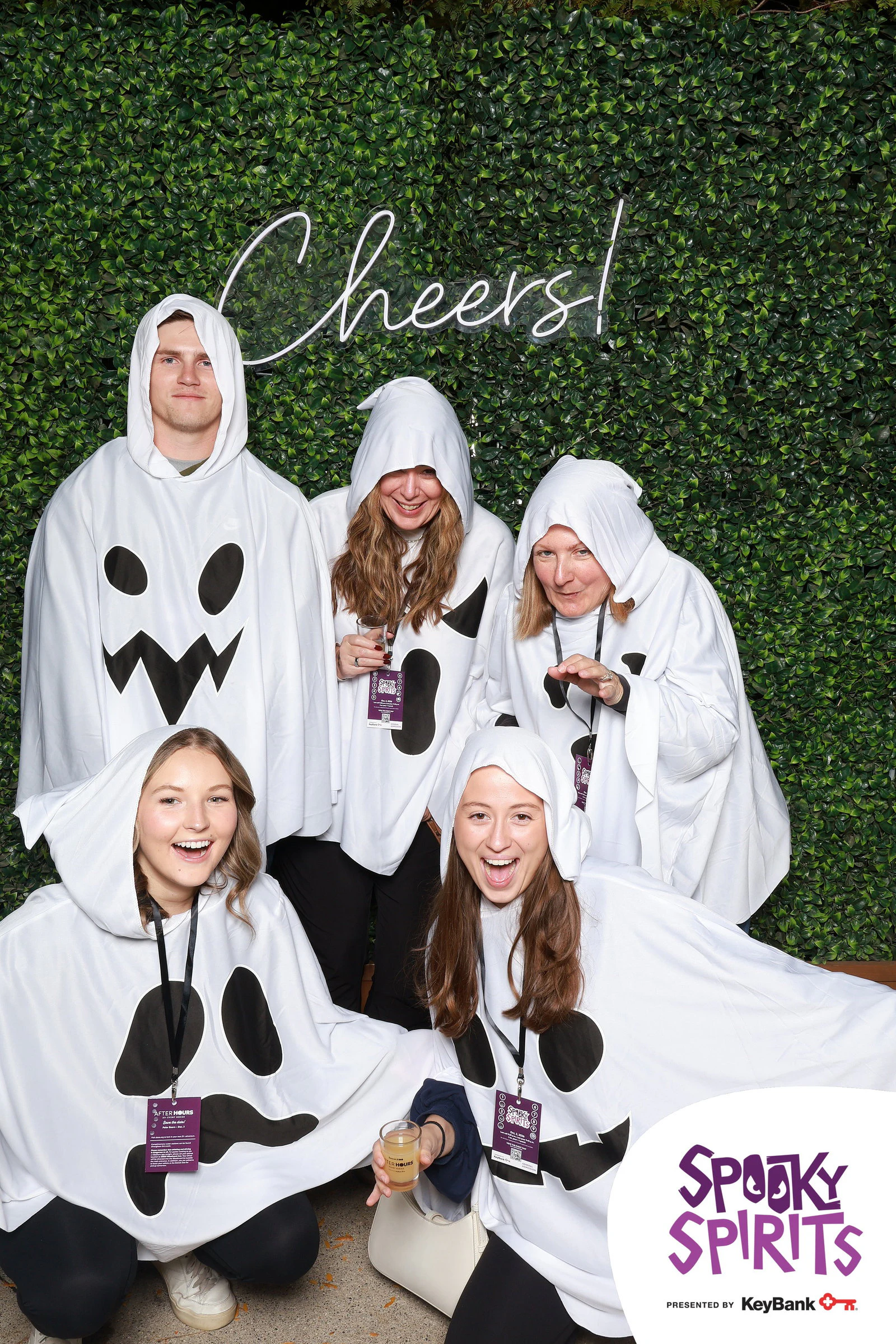 Seven friends dressed as ghosts in white sheets, two crouched in front at Spooky Spirits at the Detroit Zoo 2026