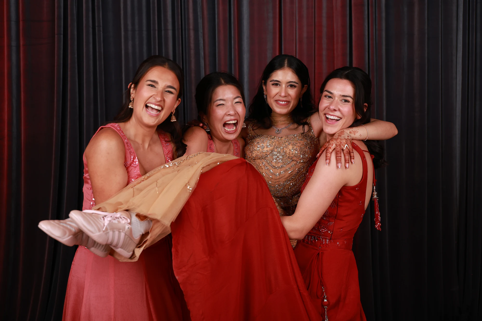 Four friends piled together mid-laugh at Puja + Curtis at State Savings Bank