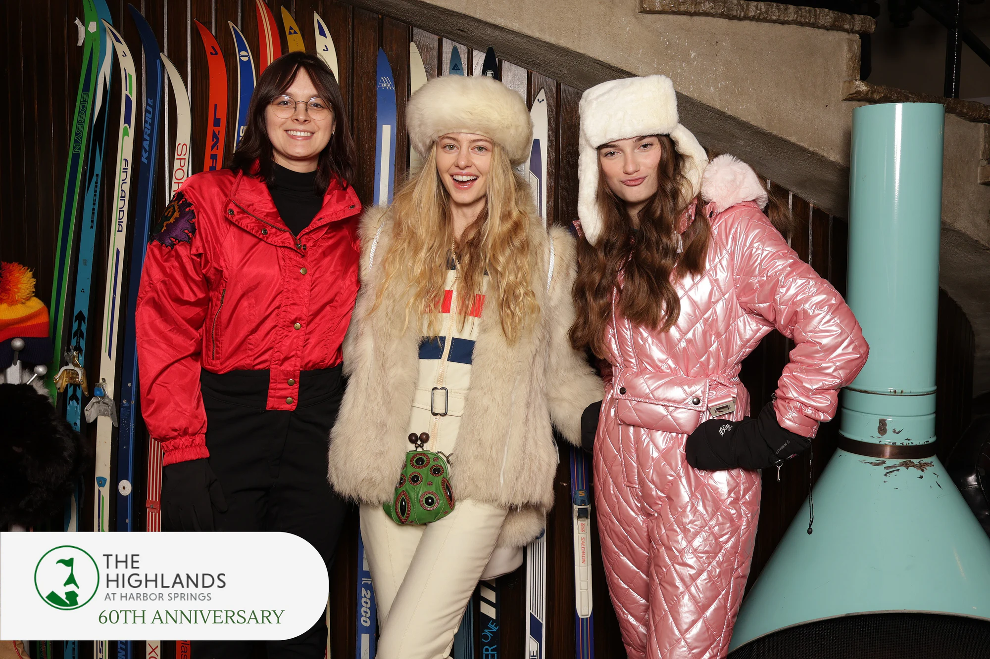 Three women in vintage ski wear: a red jacket, a white fur coat and a pink metallic snowsuit at The Highlands 60th Anniversary