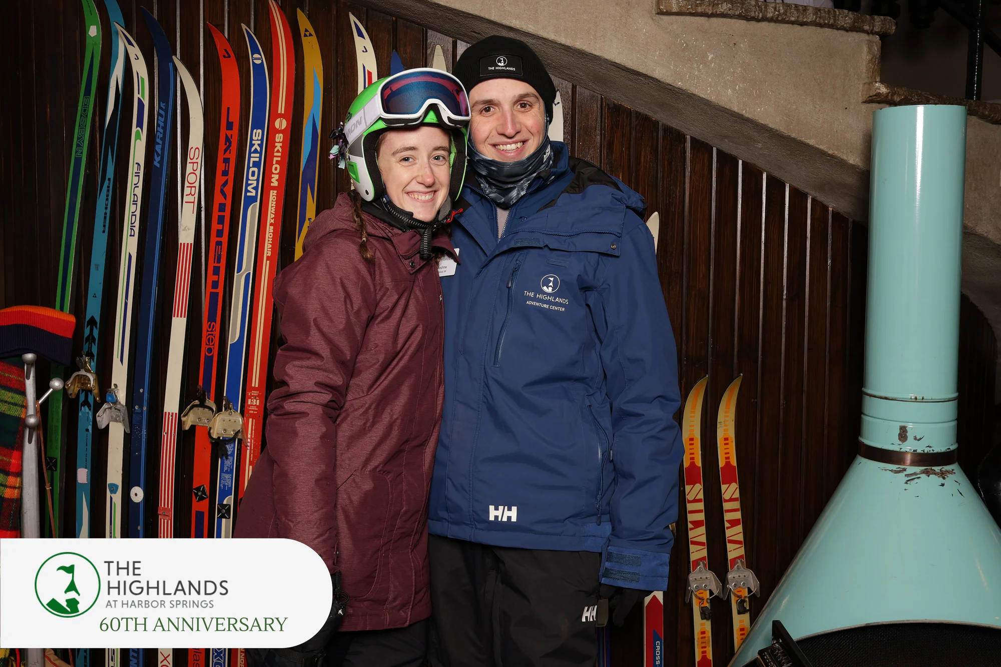 Couple in ski gear, she in a green helmet and goggles, both smiling at The Highlands 60th Anniversary