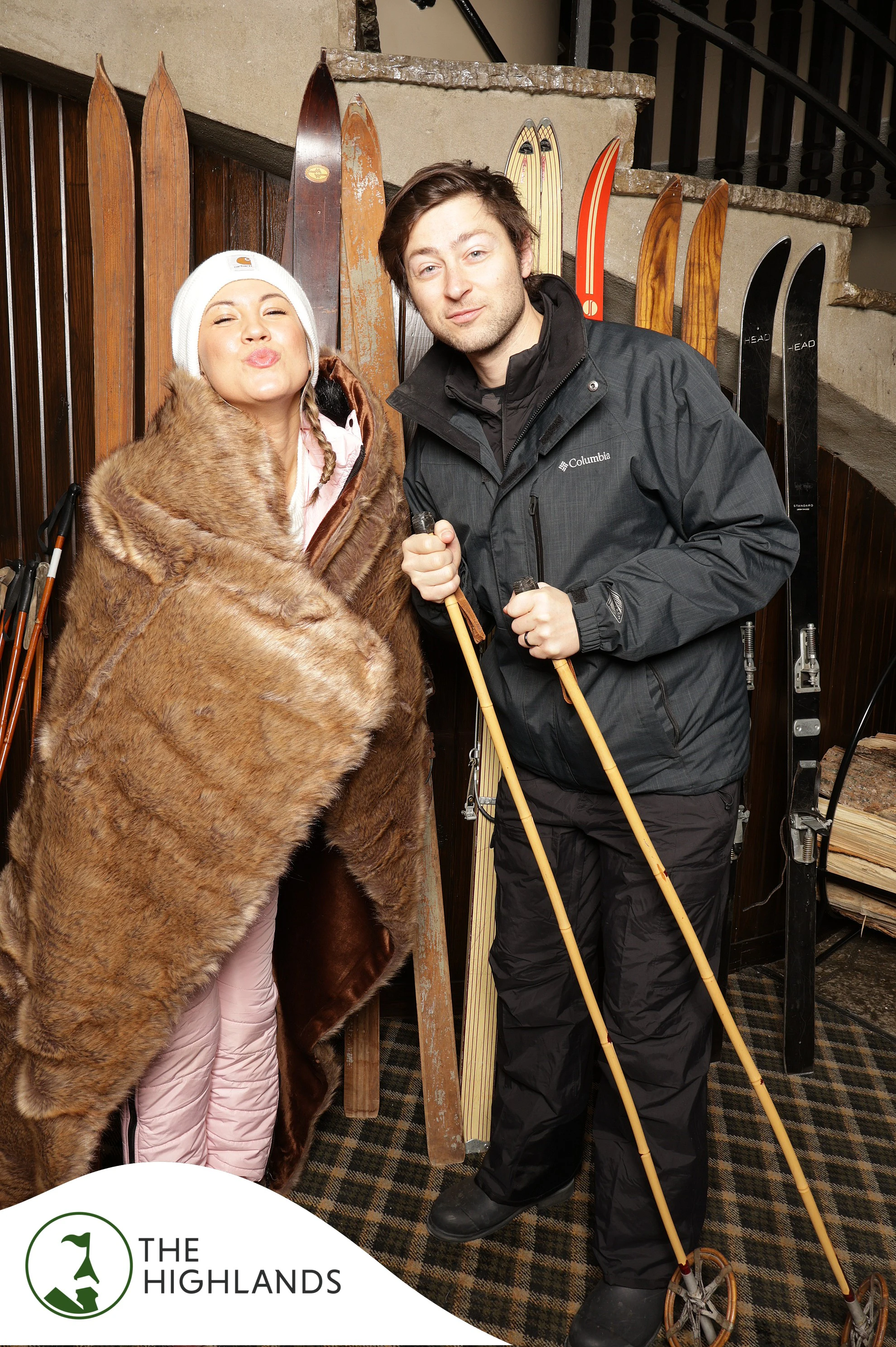 Couple with vintage wooden ski poles, she wrapped in a faux fur throw at The Highlands 61st Anniversary