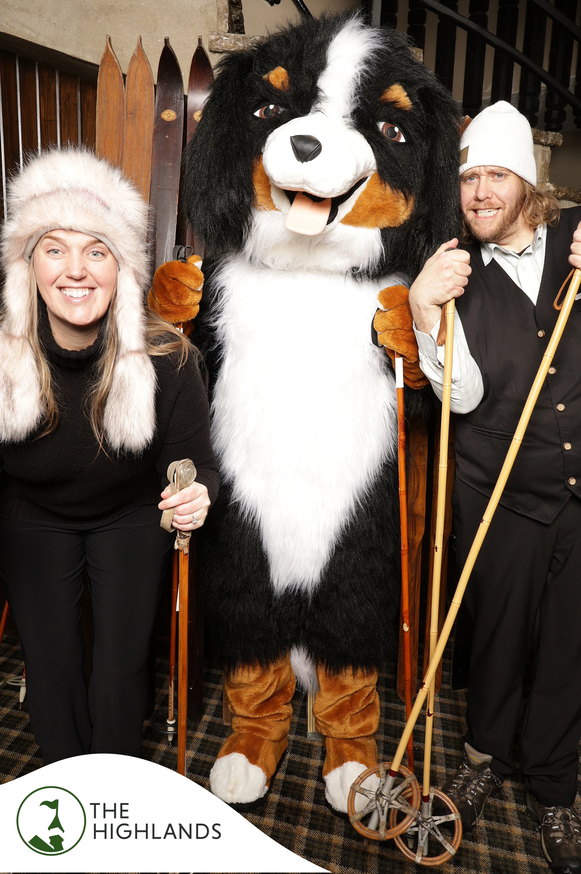 The woman, the man and the dog mascot smiling with their ski poles at The Highlands 61st Anniversary