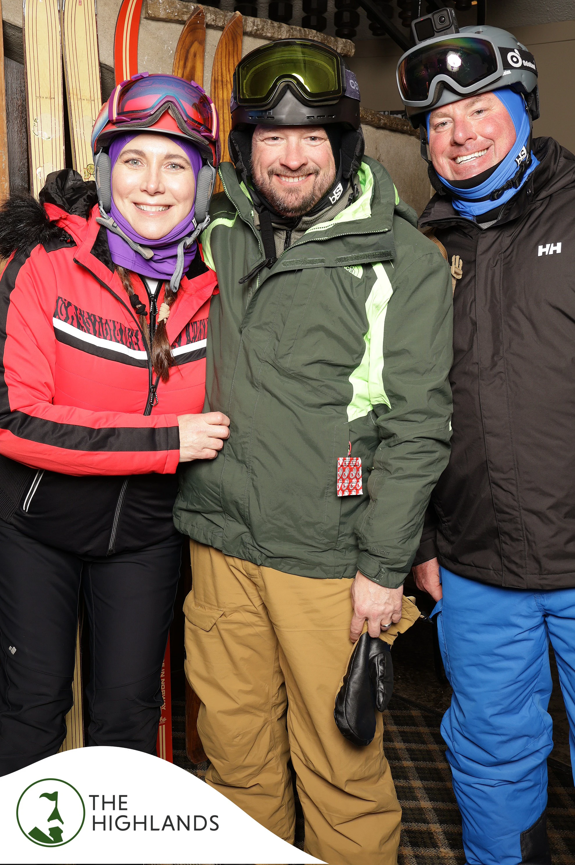 Three friends in ski jackets and helmets, goggles pushed up at The Highlands 61st Anniversary