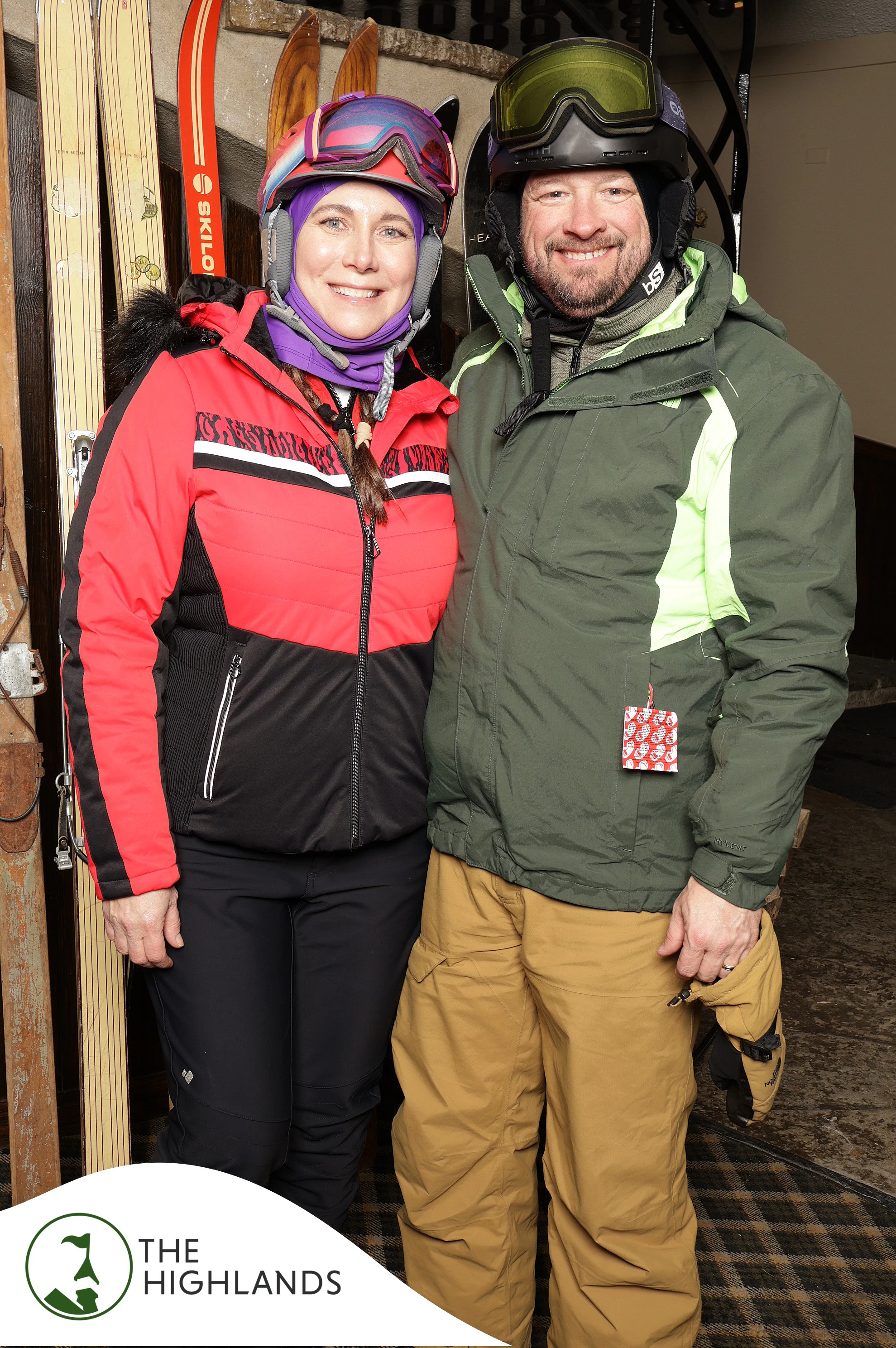 The two friends in red and green ski jackets smiling side by side at The Highlands 61st Anniversary