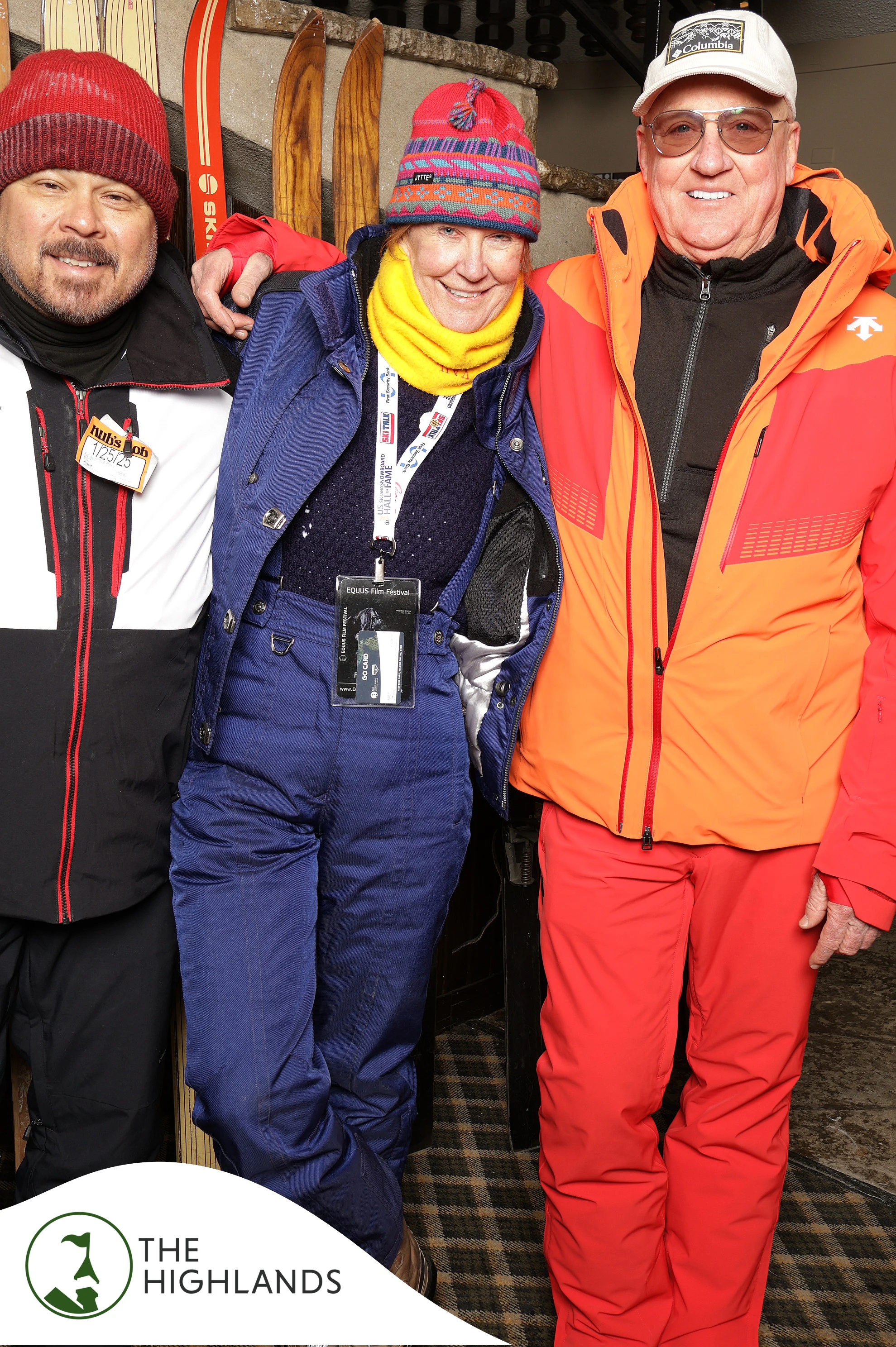 The three friends in ski gear leaning in, all smiling at The Highlands 61st Anniversary